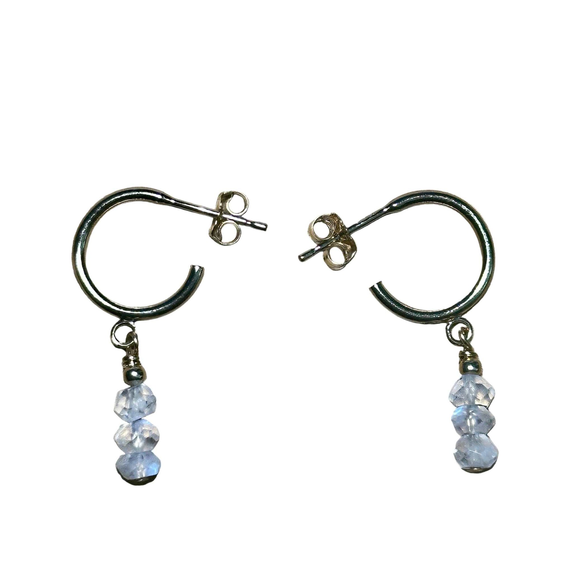 Pair of hoop earrings with Rainbow Moonstone gemstone faceted beads on a background