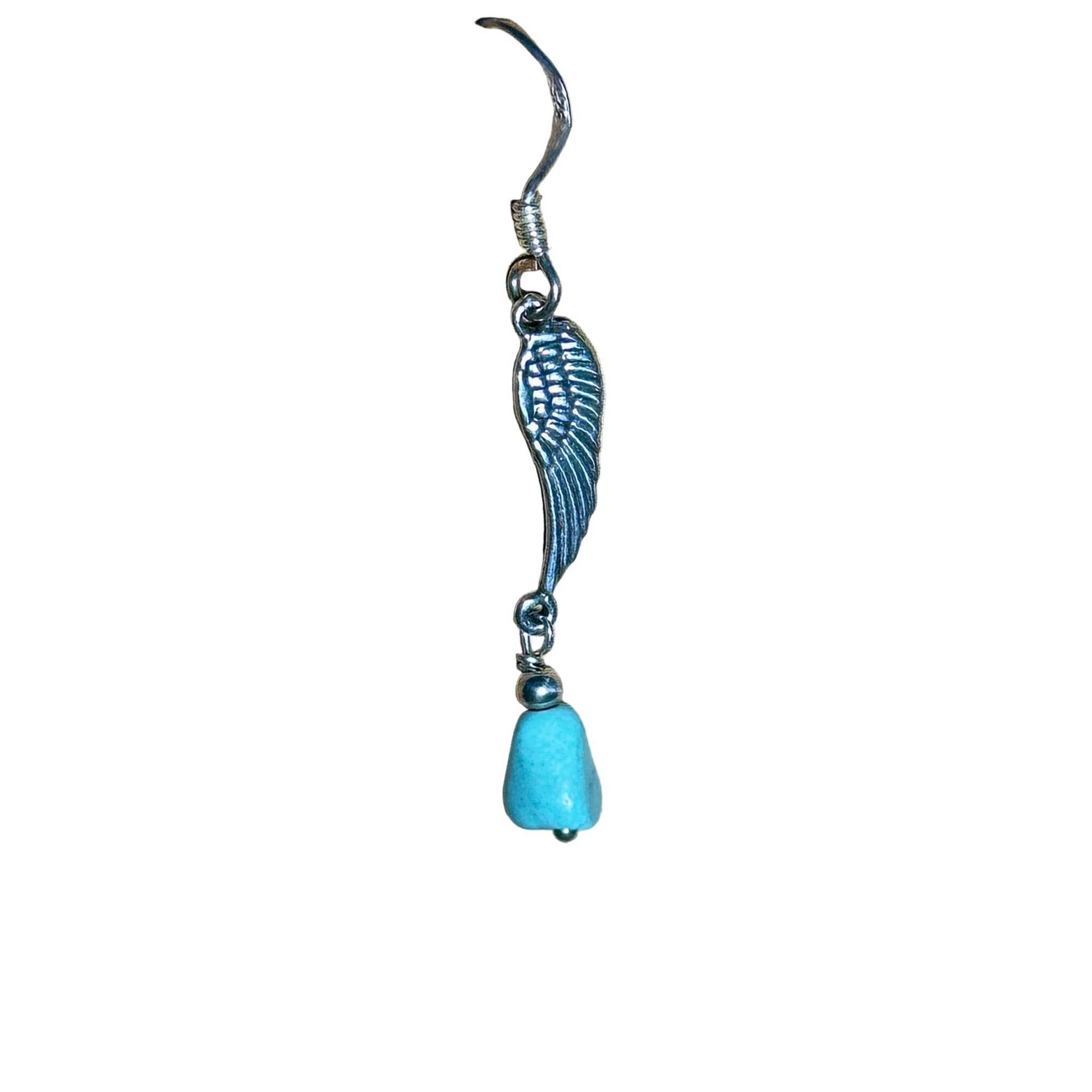 Sterling Silver earring with wing design and natural turquoise bead on a background