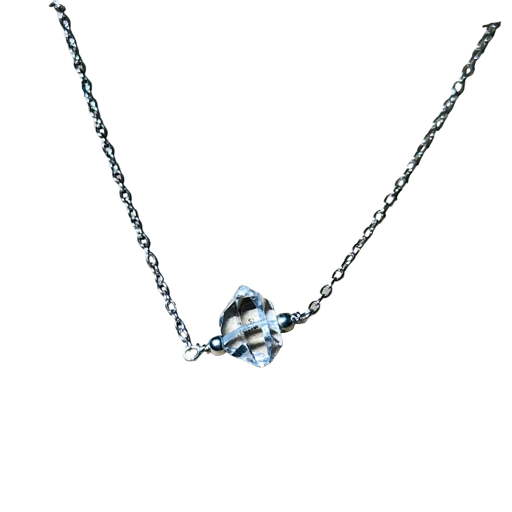 Close-up of a sterling silver Herkimer diamond necklace with a clear double-terminated quartz crystal pendant on a delicate silver chain.