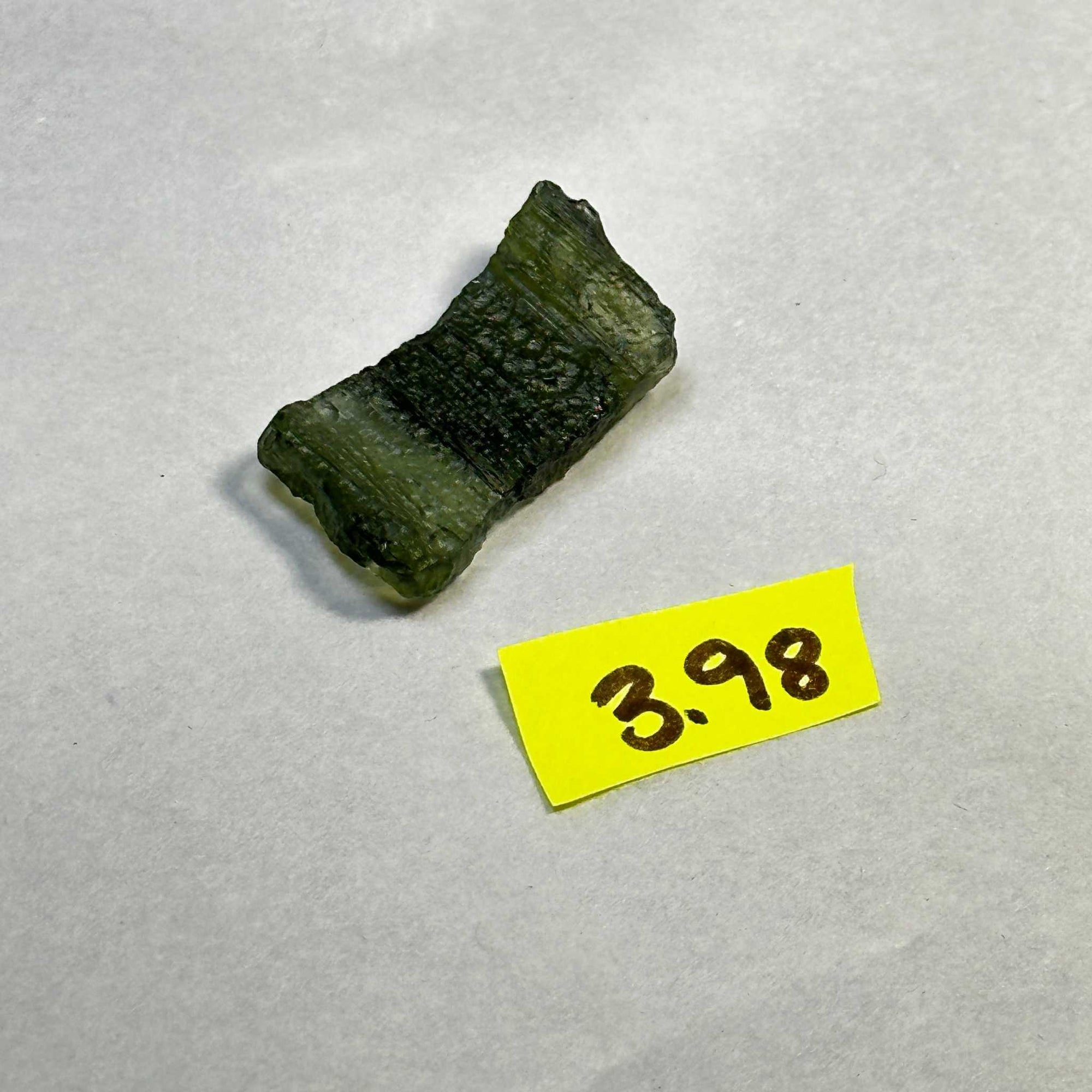 Raw Moldavite tektite stone weighing 3.98 grams from the Czech Republic with deep green translucent texture.
