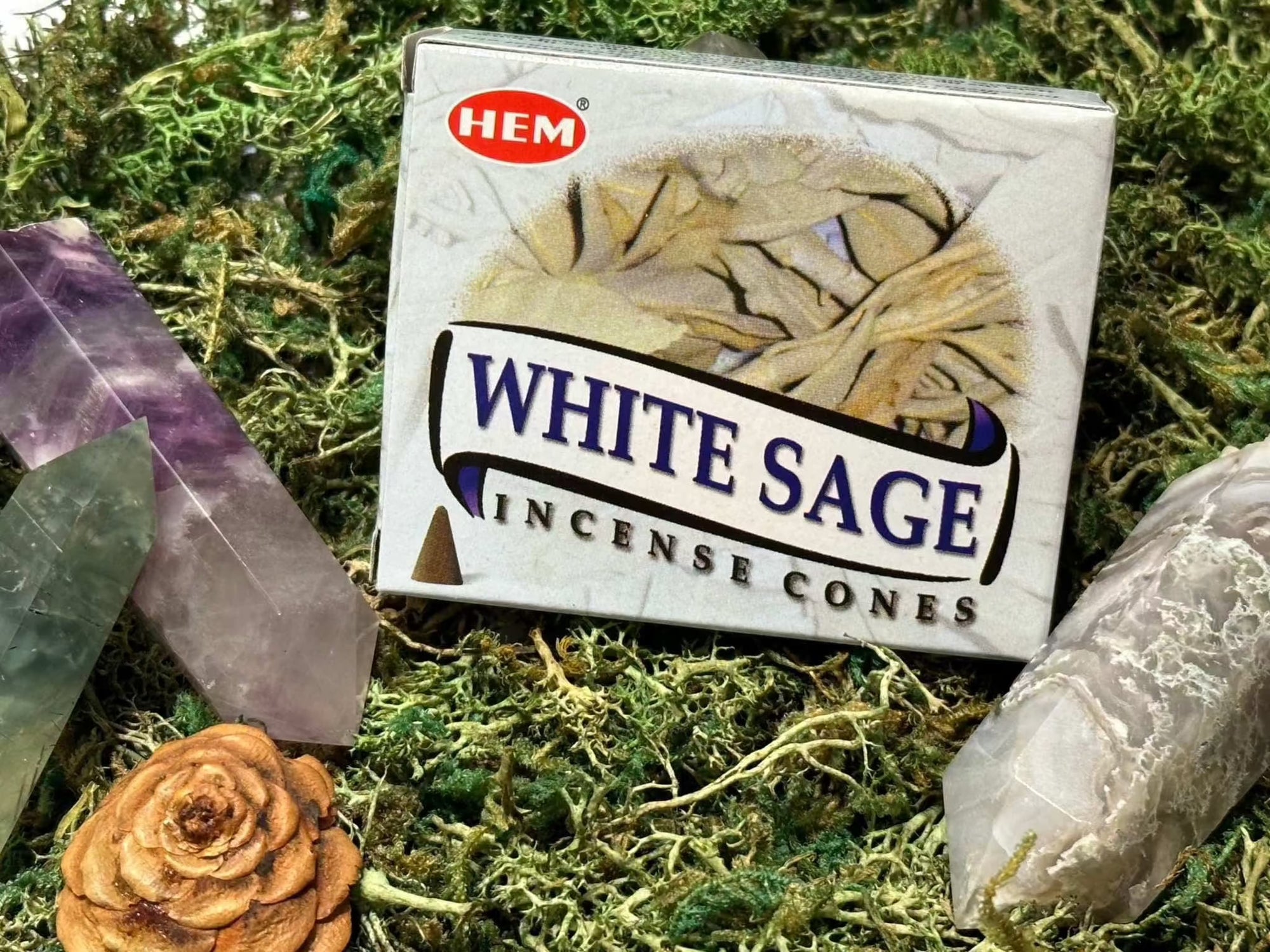 White Sage Incense Cones by HEM, with gemstones and pine cone, on moss background.