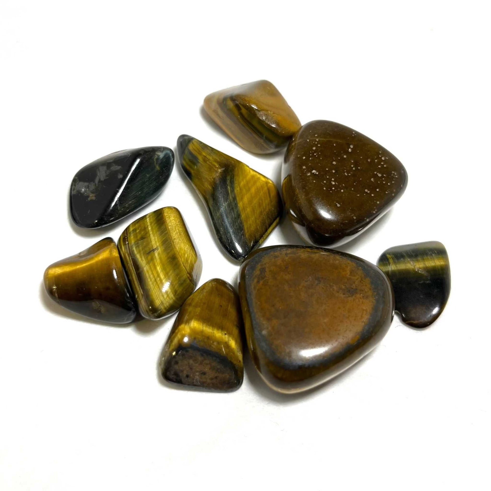 Collection of polished Tiger Eye tumbled stones with golden brown bands and smooth finish on white background