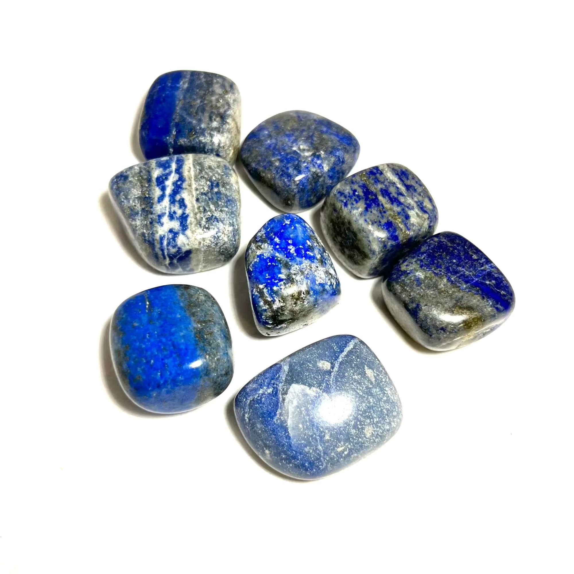 Lapis Lazuli tumbled pocket stones on a white background, showcasing deep blue hues and golden flecks.