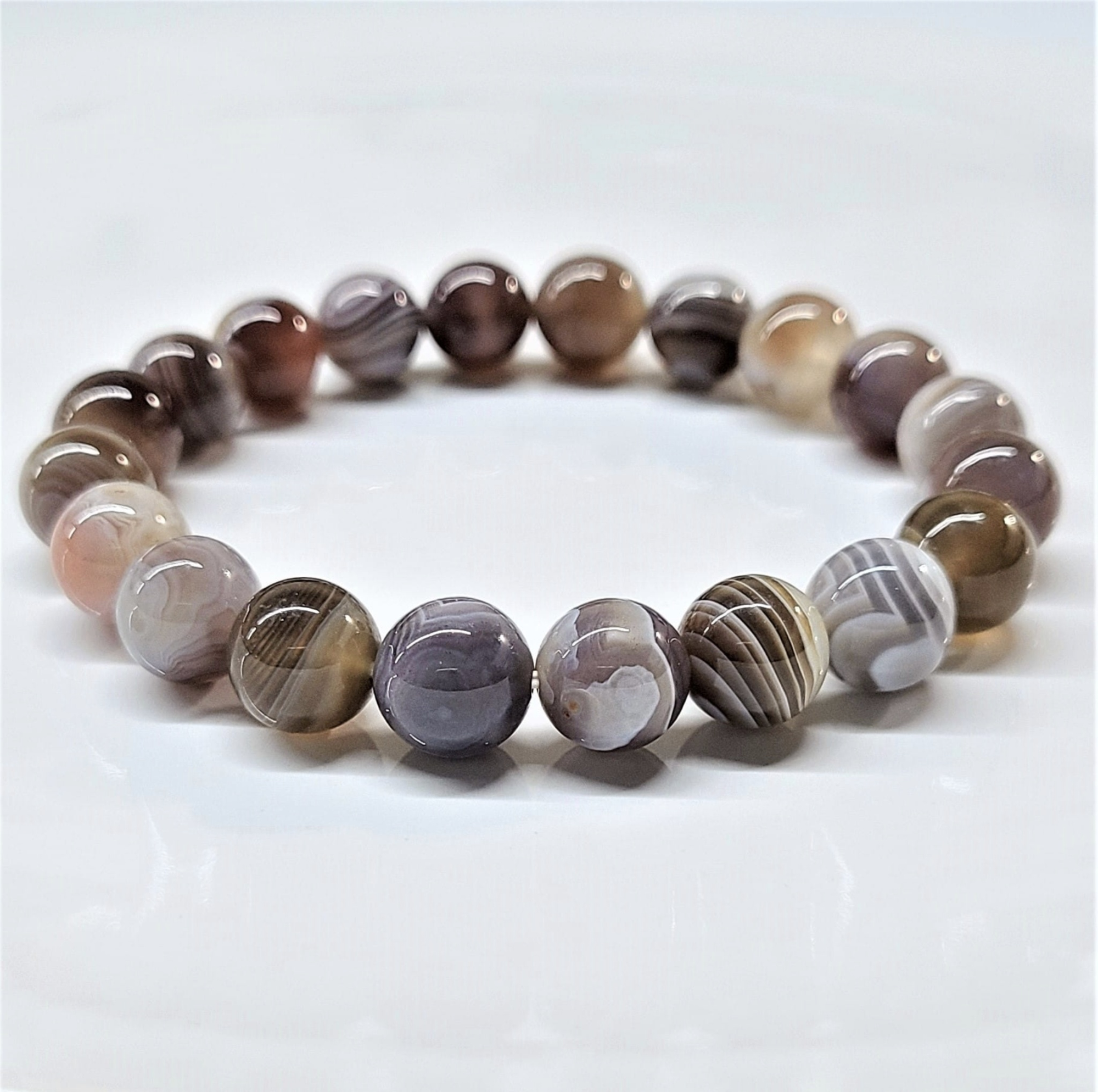 Botswana Agate stackable bracelet with round polished gemstone beads featuring natural earthy tones and intricate banding patterns.