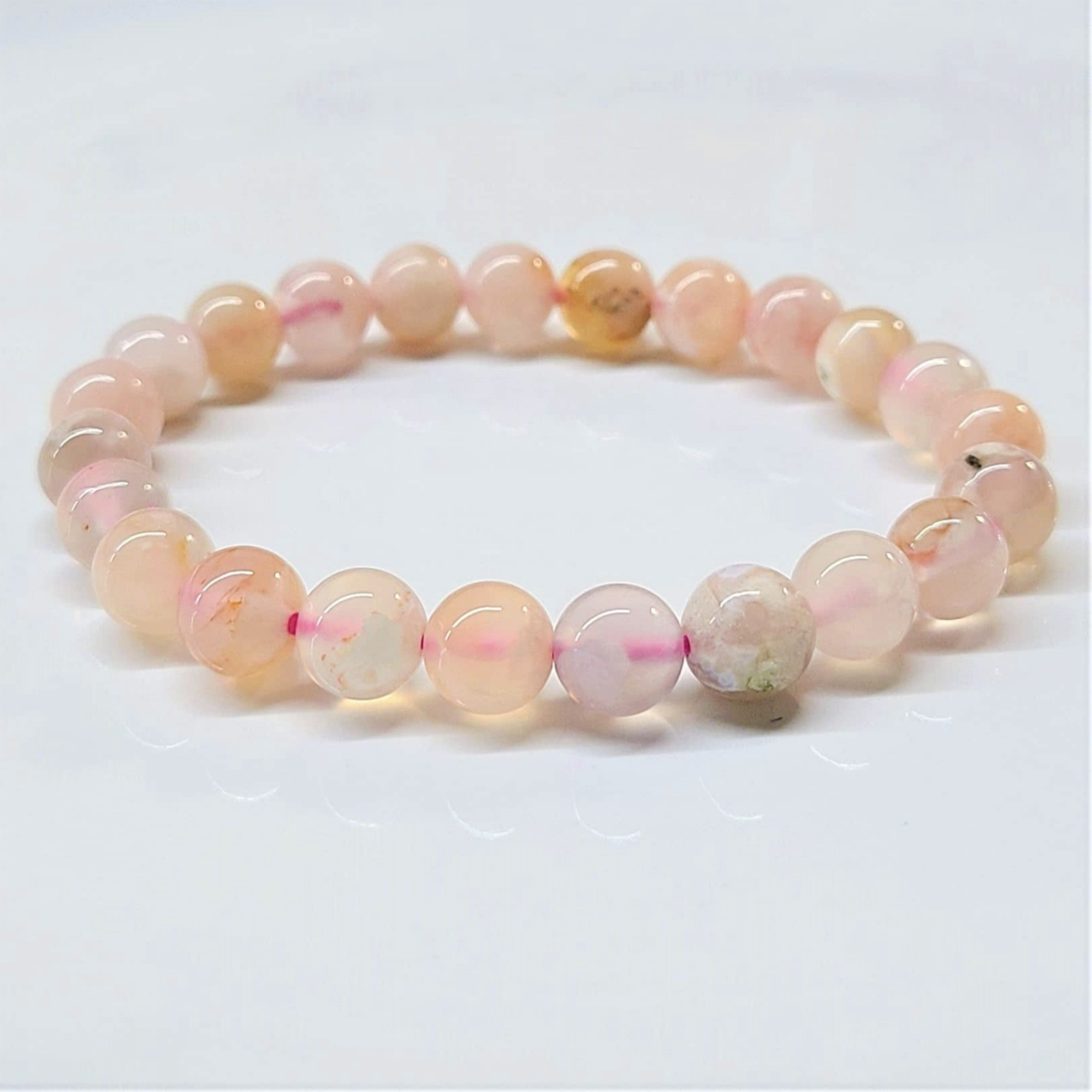 Flower Agate stackable bracelet with round pink and translucent floral-patterned beads on elastic string