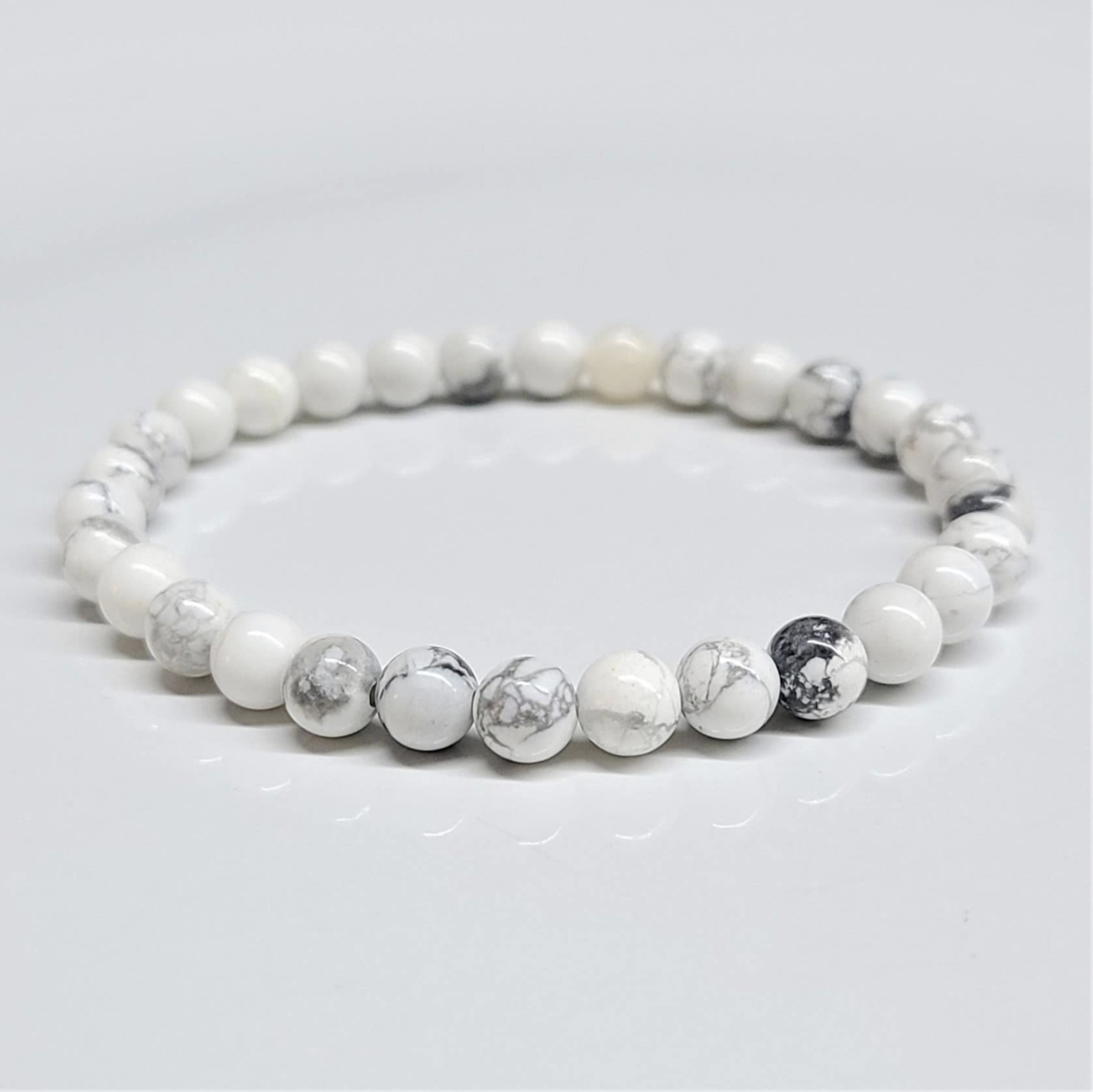 Howlite stackable bracelet with round white beads featuring gray veining for calming and stress relief.