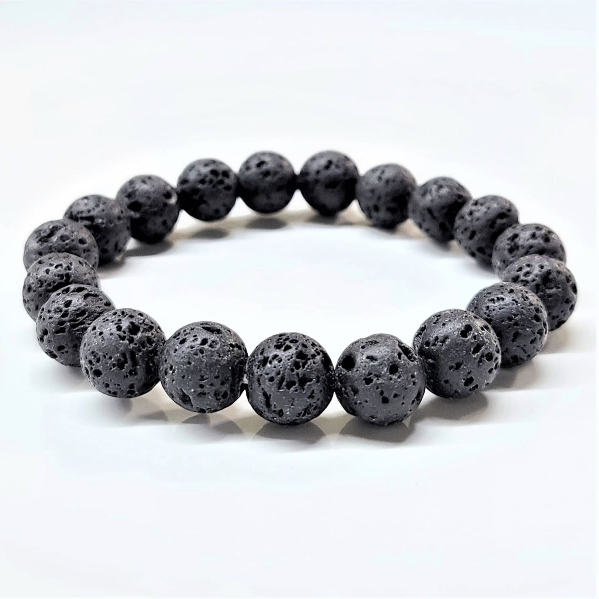 Black lava stone round bead stackable bracelet with porous textured surface, natural grounding and metaphysical properties.