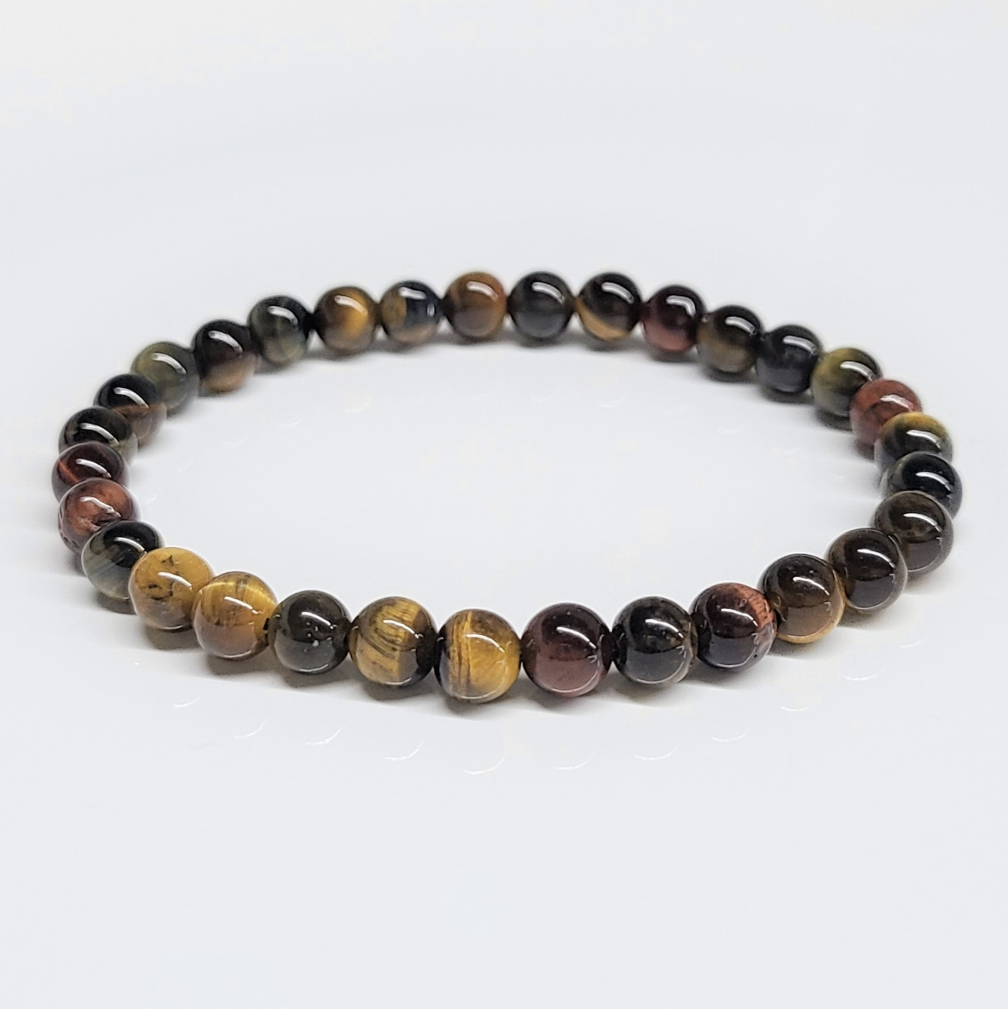 Multi-color tiger eye round bead stackable bracelet with gold, blue, and red hues for personal power and metaphysical benefits