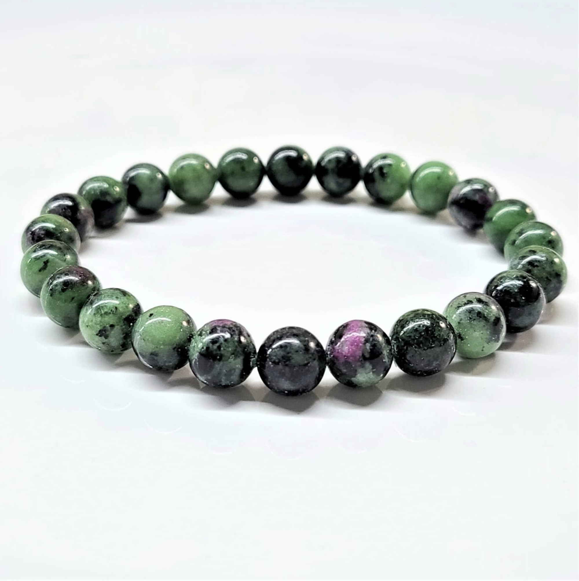 Ruby Zoisite stackable bracelet with round green and pink gemstone beads, adjustable fit, promoting emotional balance and spiritual growth.
