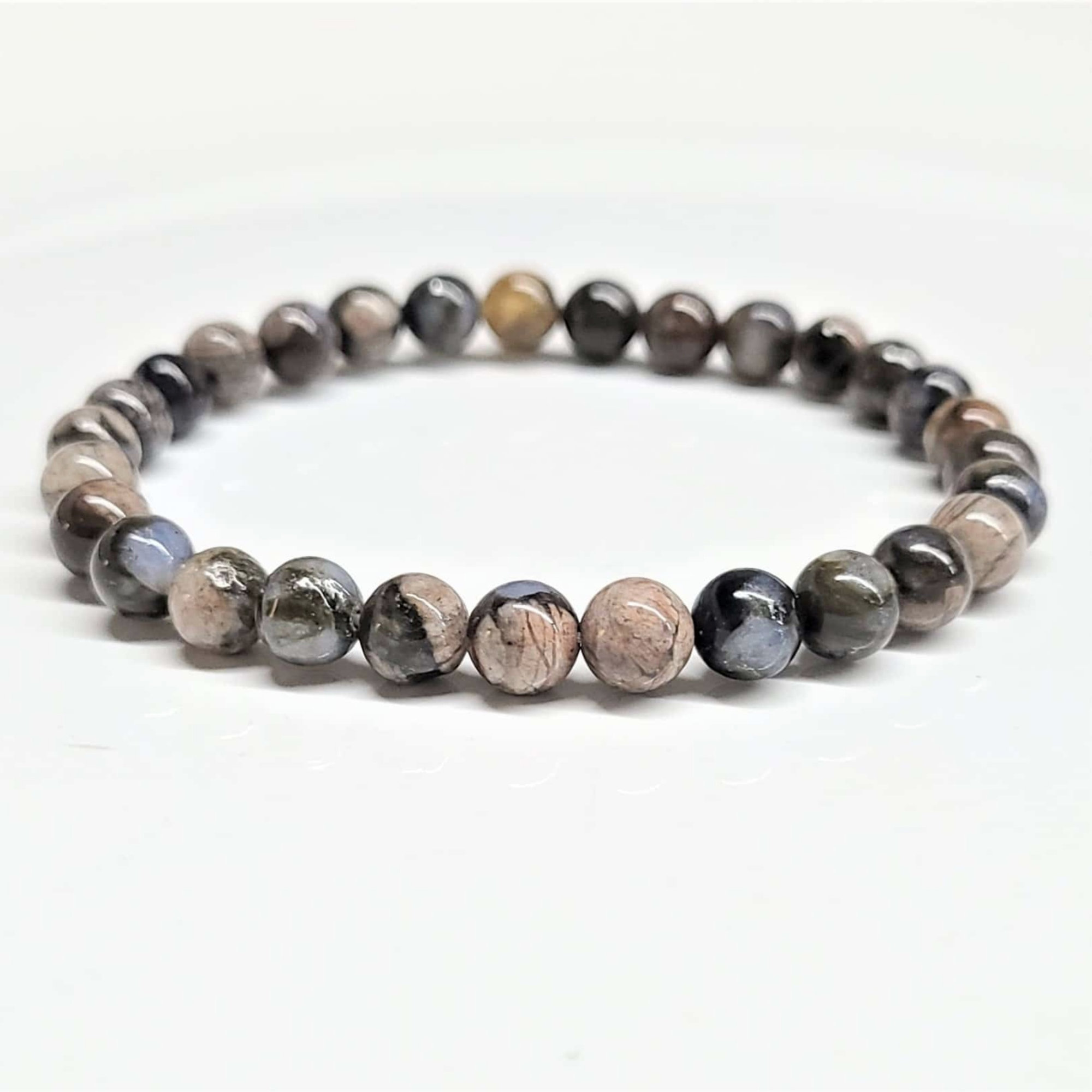 Que Sera round bead stackable bracelet featuring multi-colored speckled natural stones.