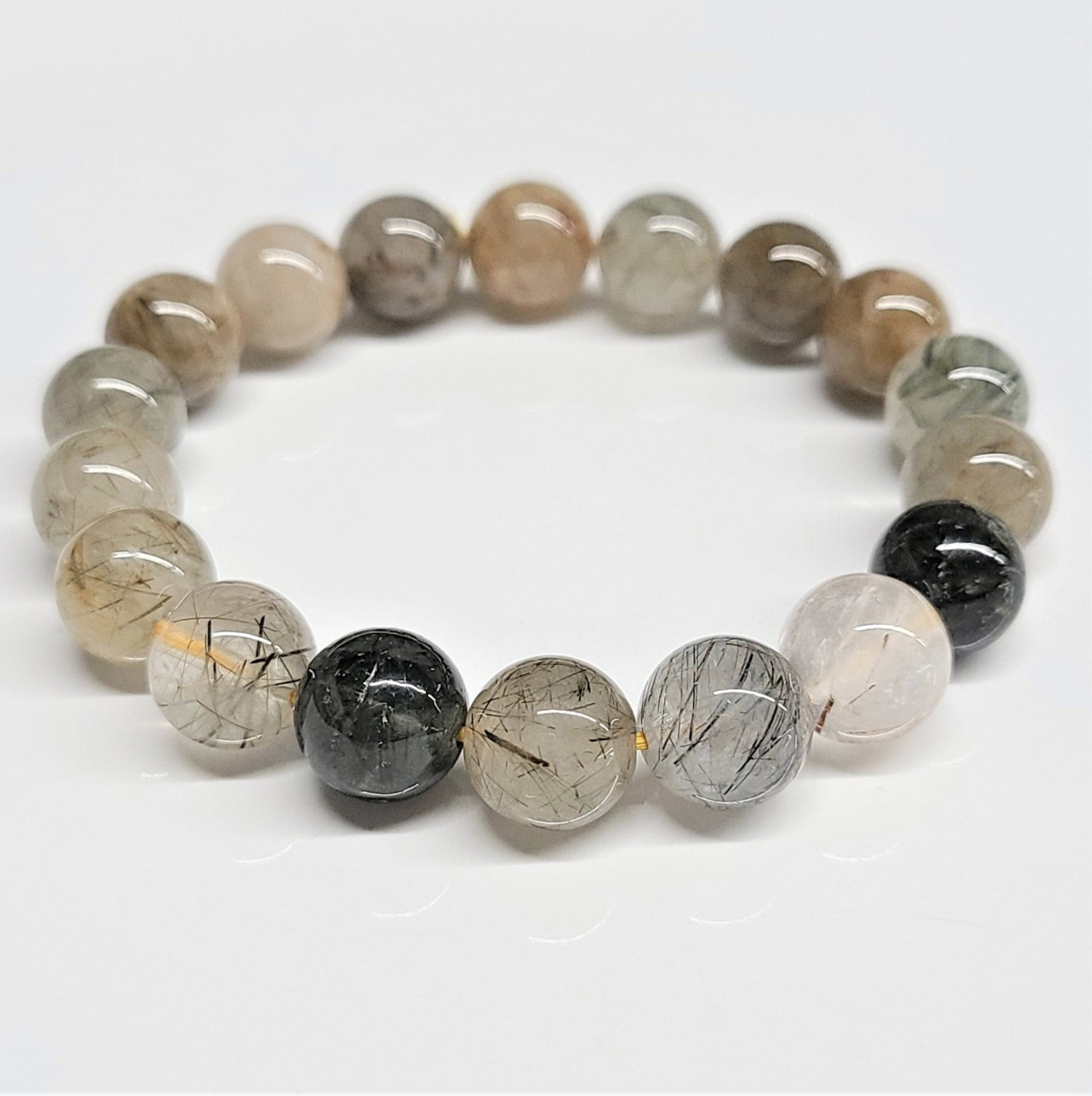 Rutilated quartz round bead bracelet with 10mm stackable beads featuring golden and silver needle-like inclusions.