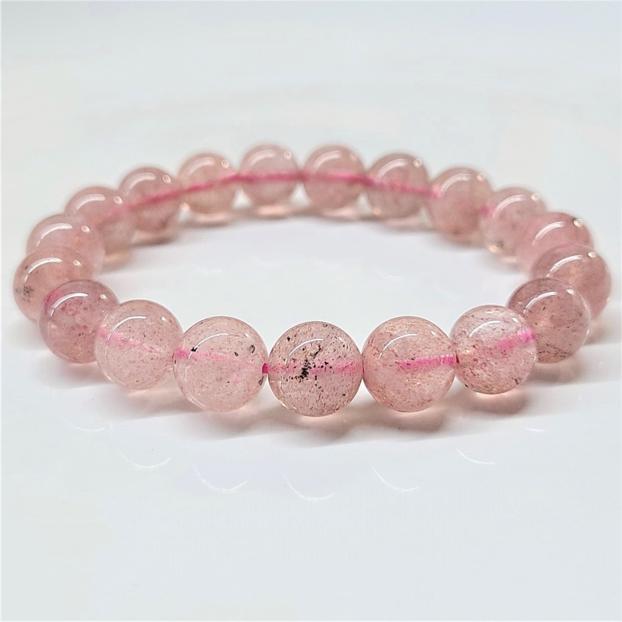 Strawberry Quartz round bead stackable bracelet with pinkish-red hues and natural inclusions.