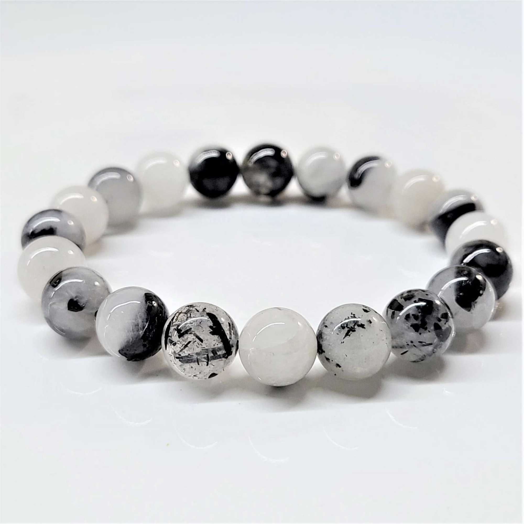Quartz stackable bracelet featuring round beads of black tourmaline in clear quartz for grounded purification and energy protection.
