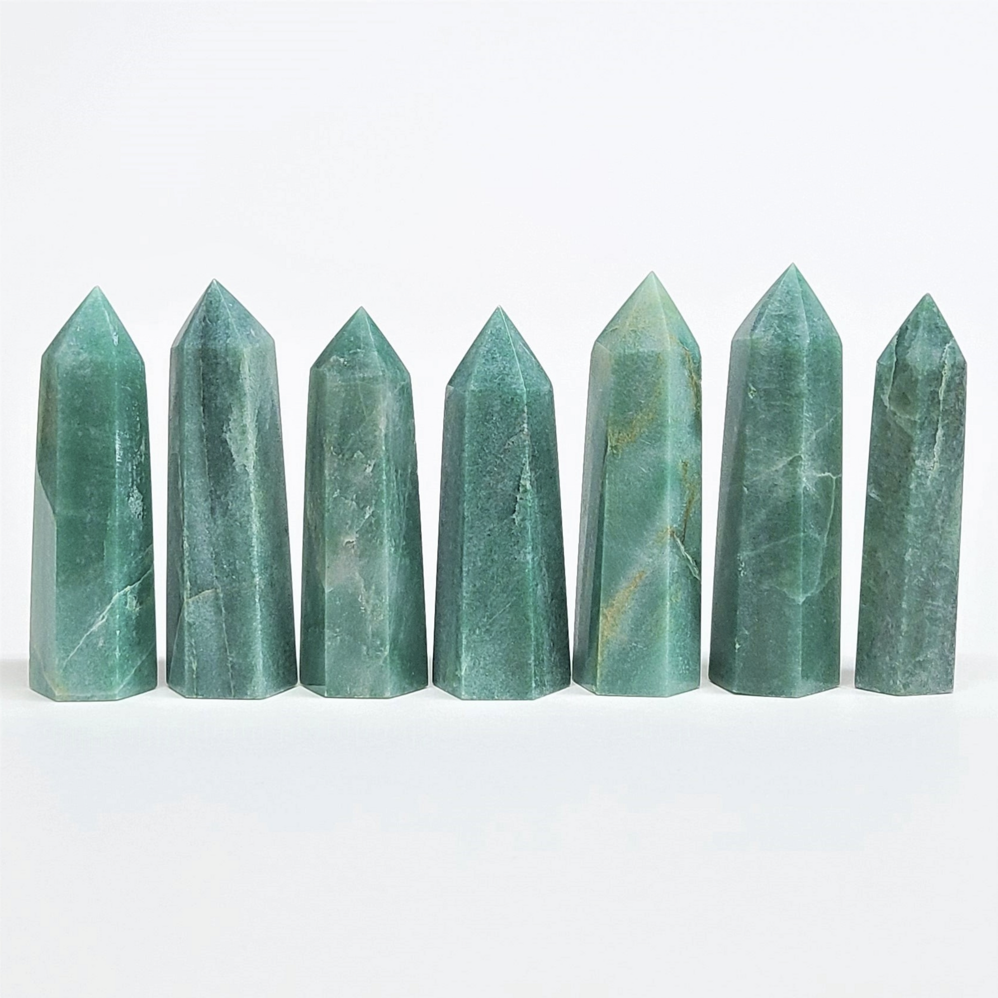 Green Aventurine crystals lined up, known for opportunity and abundance, ideal for manifestation and emotional clarity.