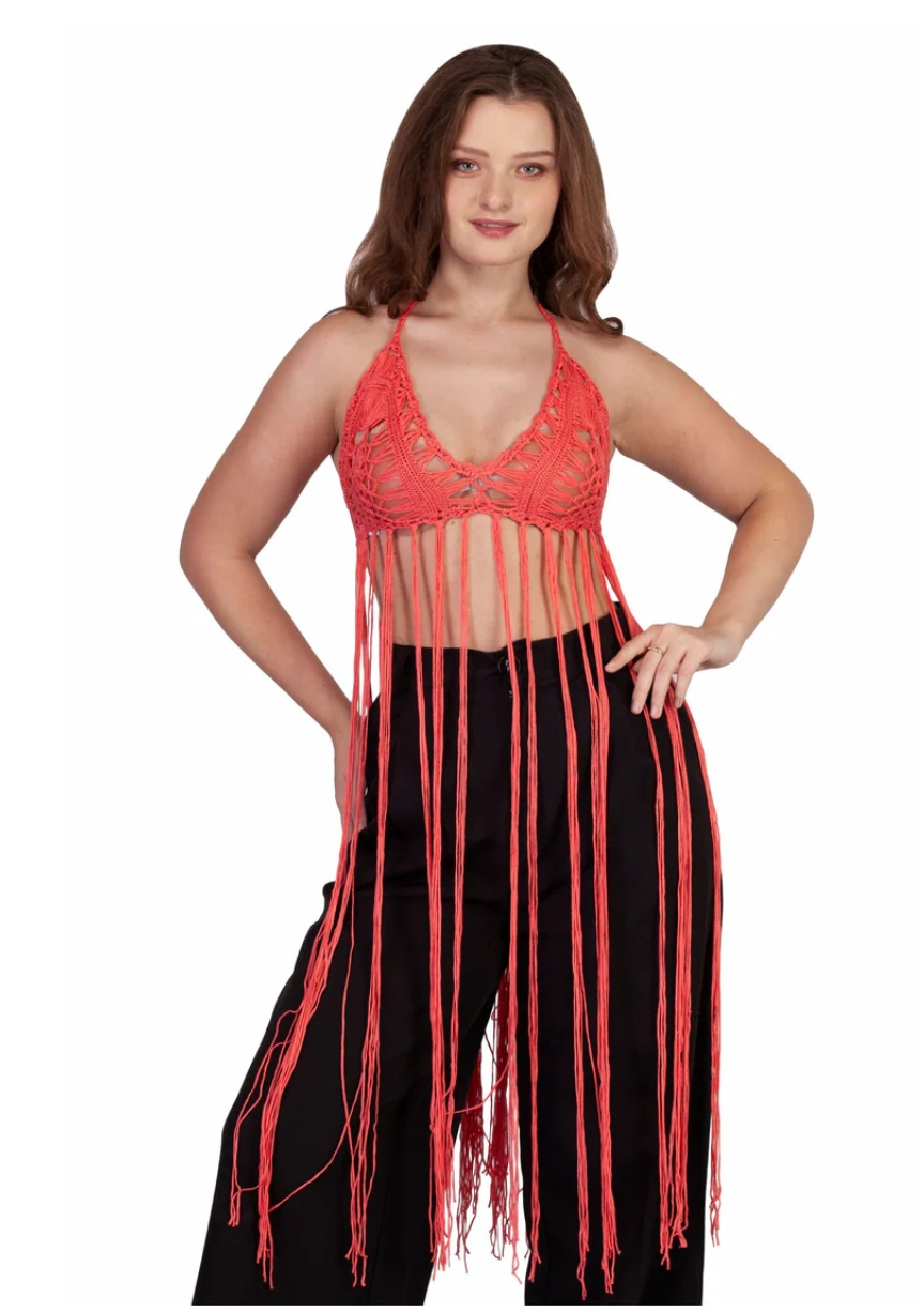 Woman wearing a red crotchet bikini top with long fringe paired with black pants, ideal for festivals.
