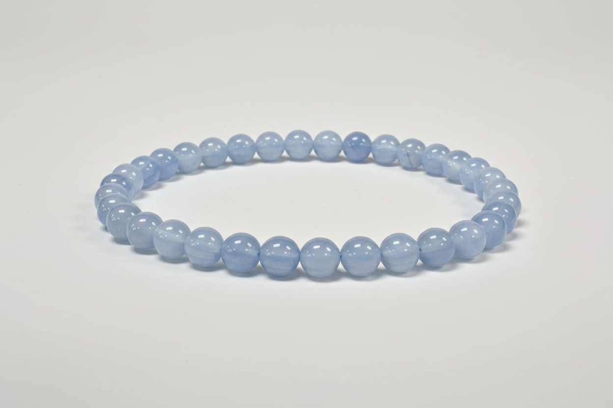 Blue gemstone bracelet on a white surface with a blurred background