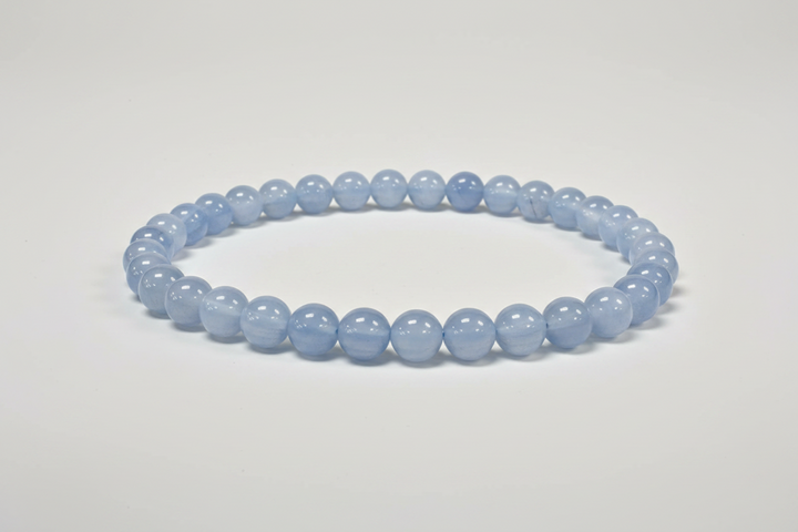 Blue gemstone bracelet on a white surface with a blurred background