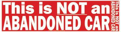 Red bumper sticker with white bold text saying "This is NOT an ABANDONED CAR"