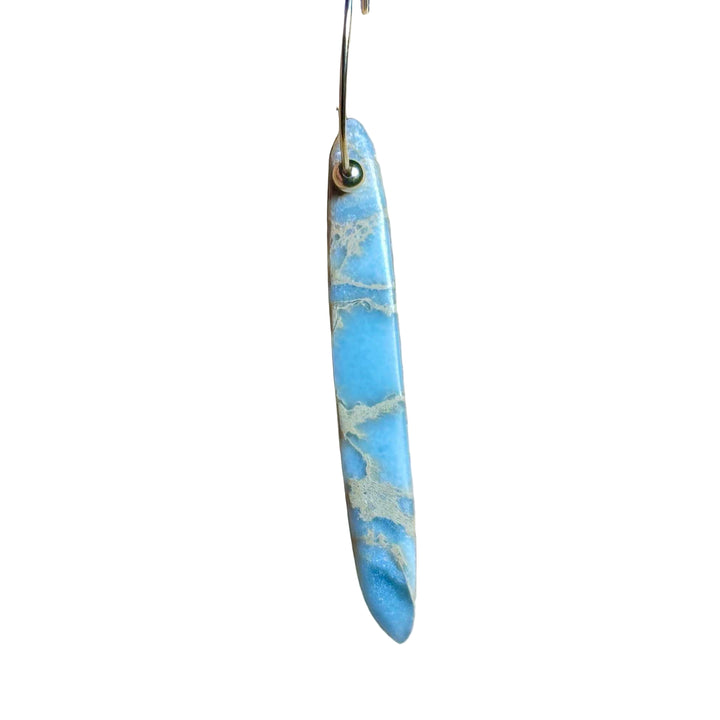 Gold Hoop earrings with blue marbled African Opal stone pendant on a background