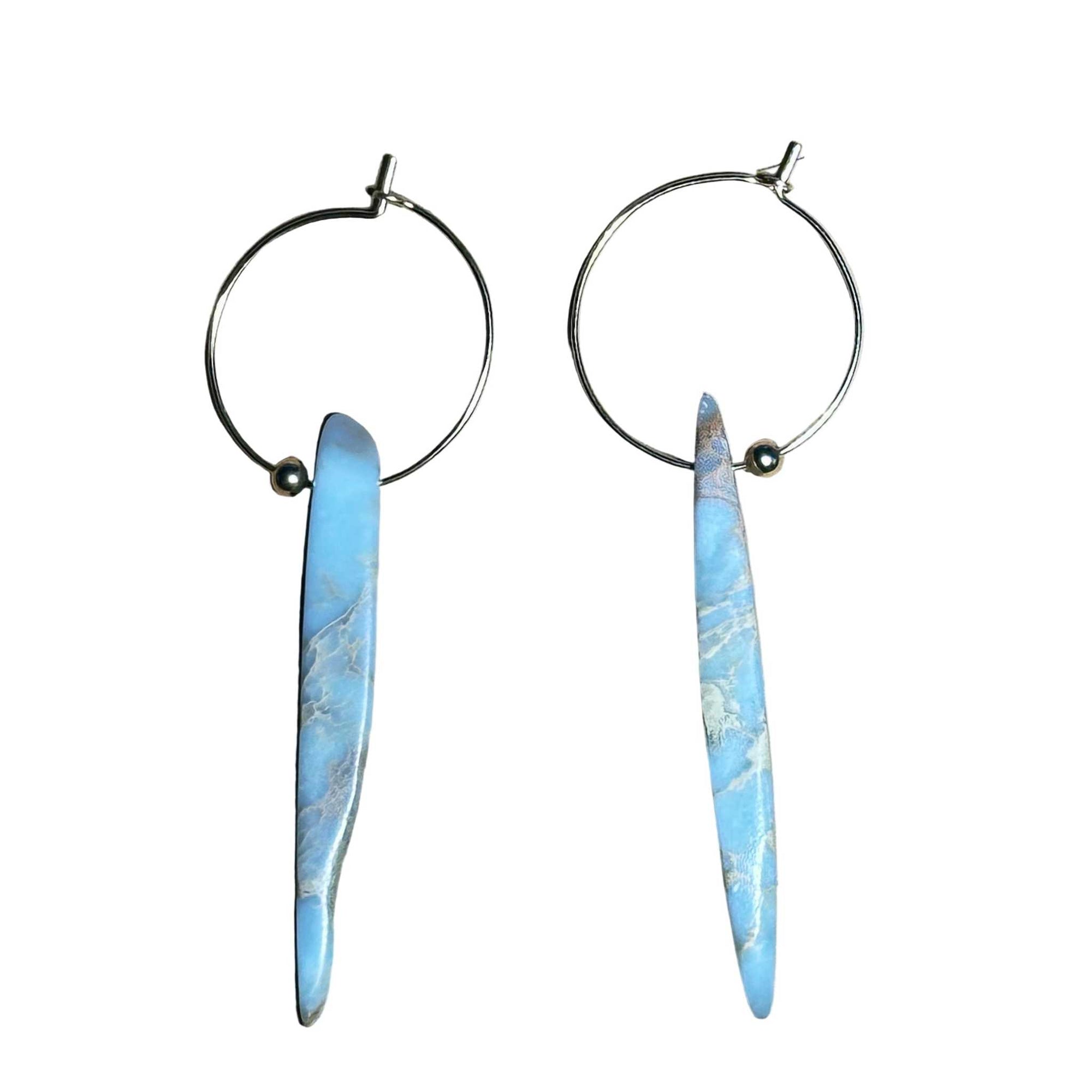 Gold Hoop earrings with blue marbled African Opal stone pendant on a background