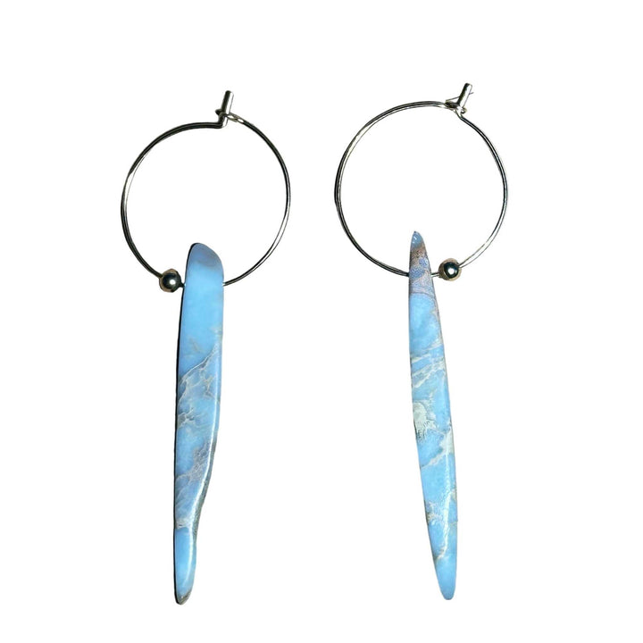Gold Hoop earrings with blue marbled African Opal stone pendant on a background