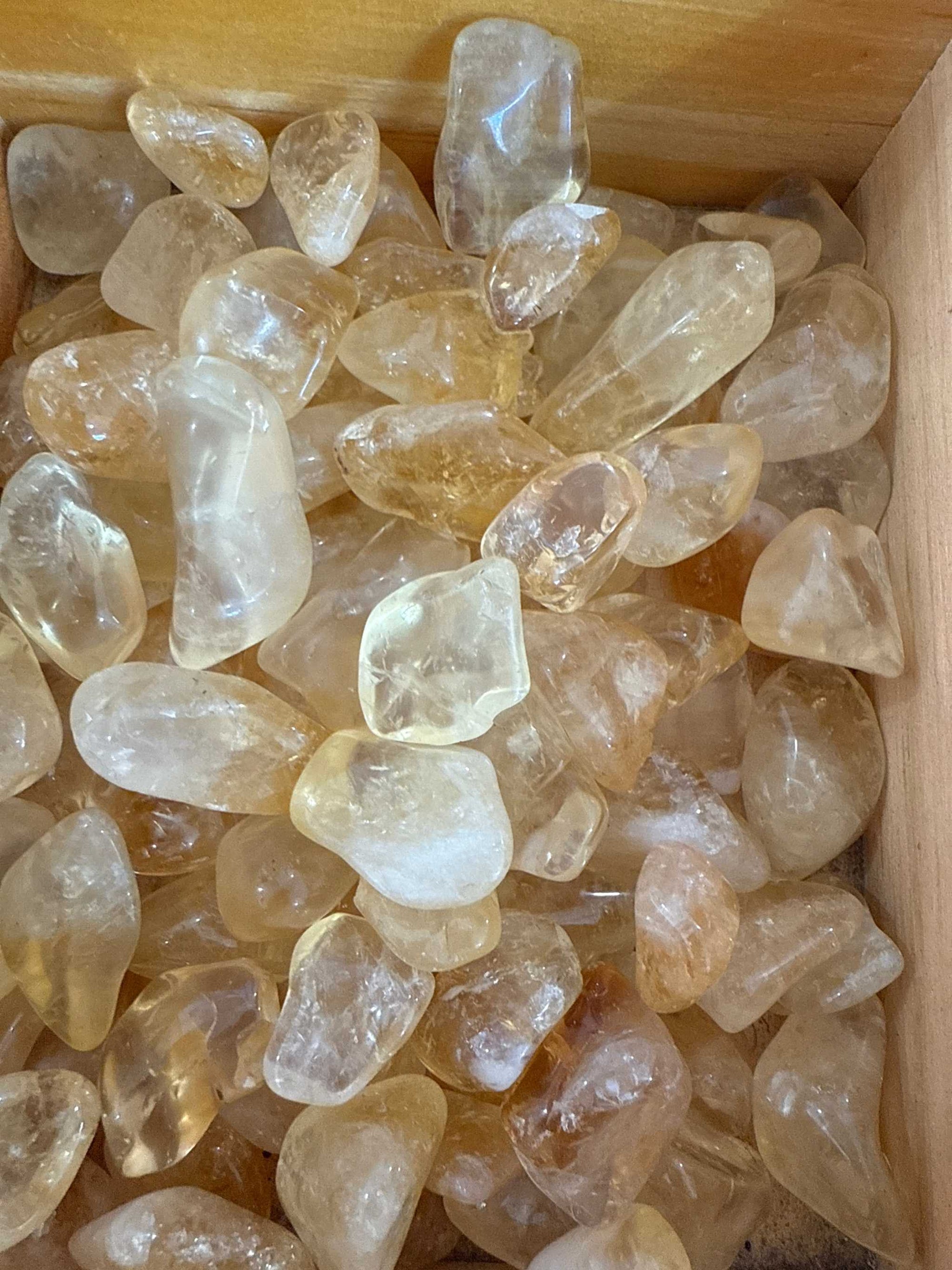 Citrine tumbled pocket stones in wooden box.