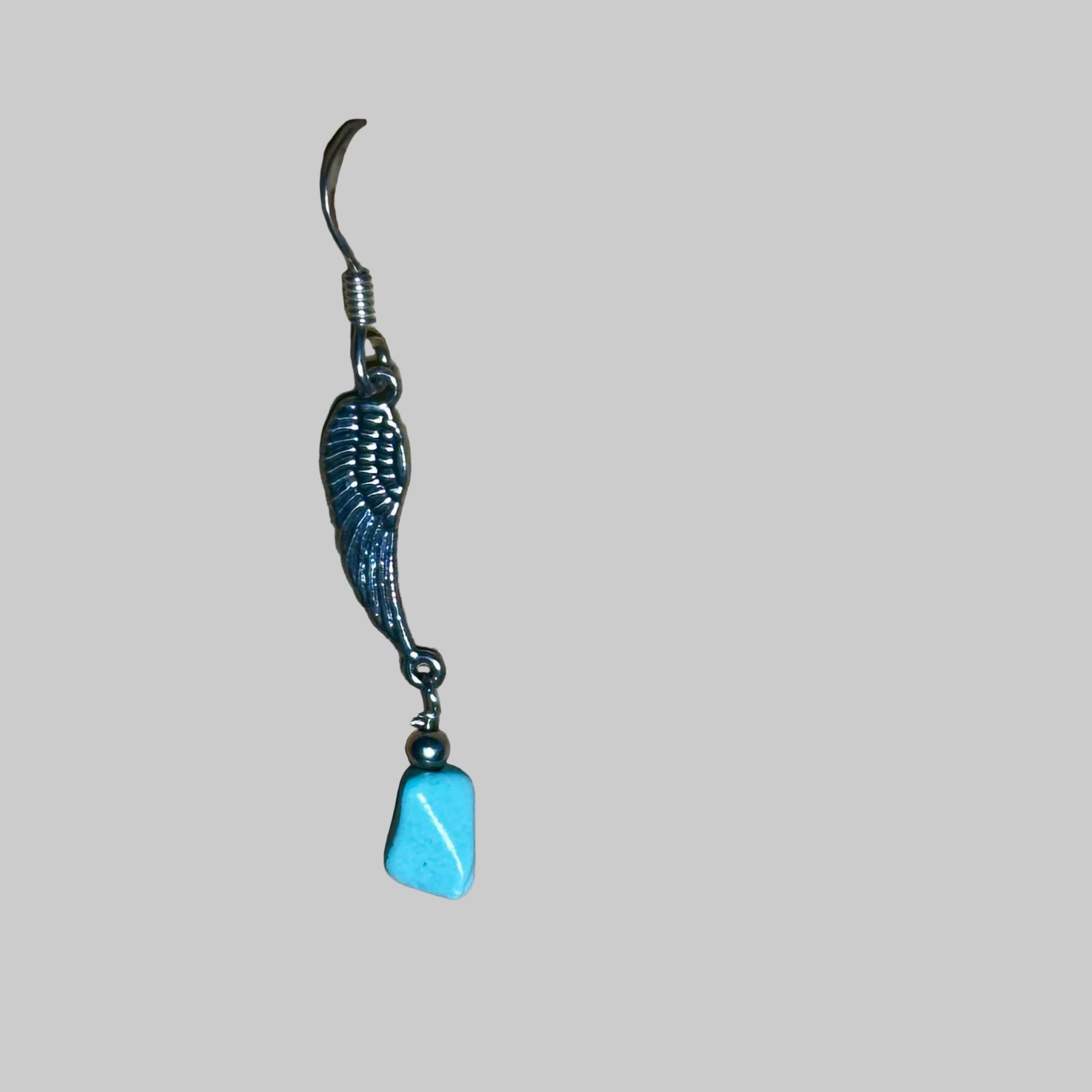 Jewelry with a blue natural Turquoise stone and feather design on a surface