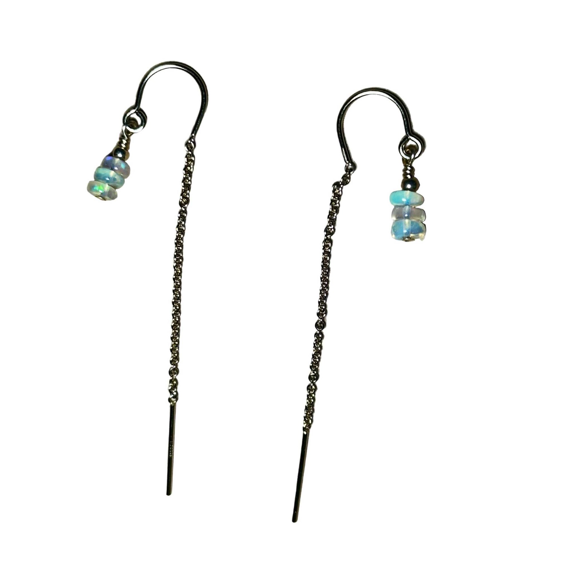 Pair of threader earrings with flashy opal beads on a surface
