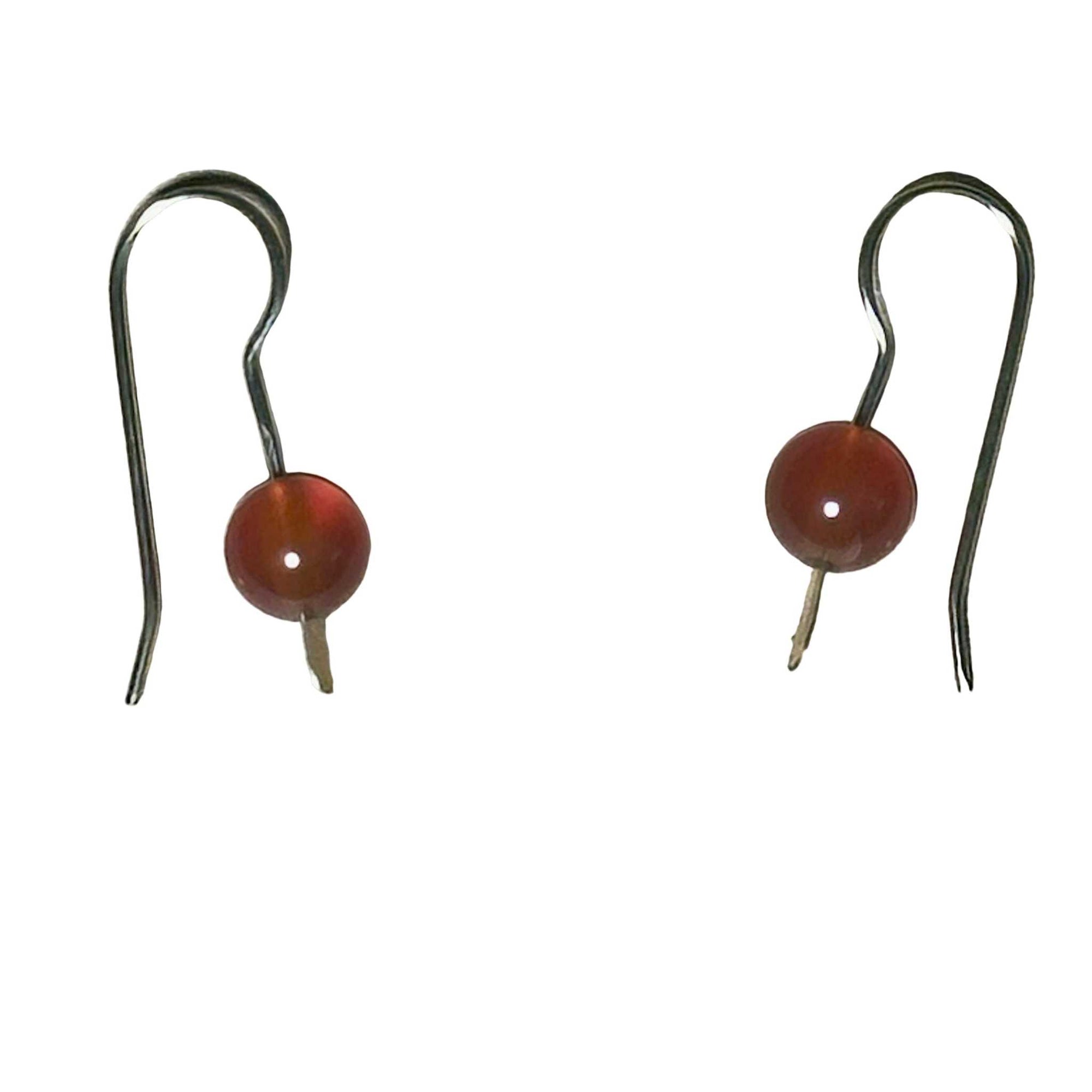 Pair of Gold Earrings with red Carnelian stones on a background
