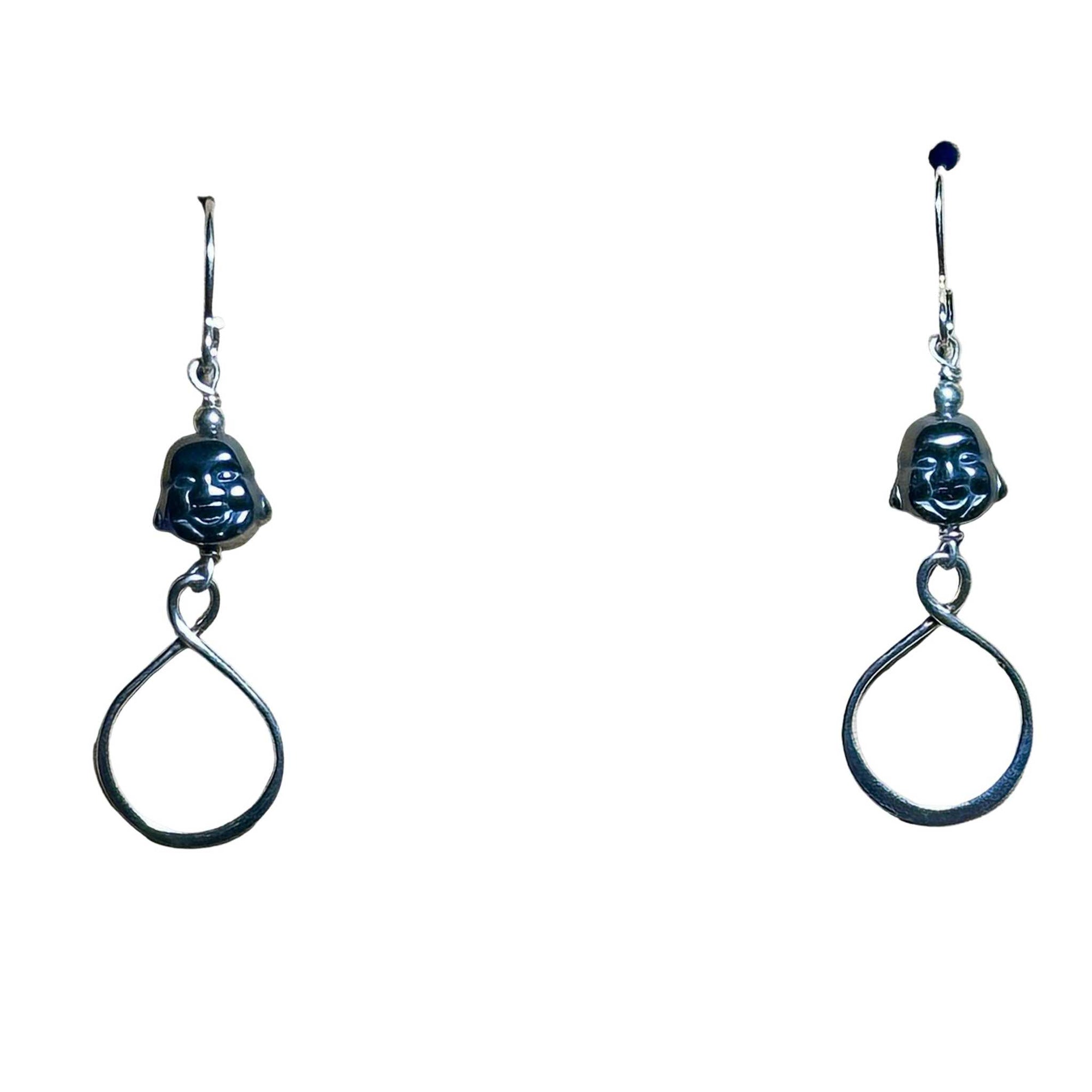 Pair of silver earrings with circular designs with Hematite Buddha head bead on a white background