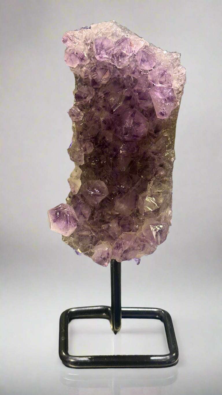Amethyst crystal on a stand in a display case