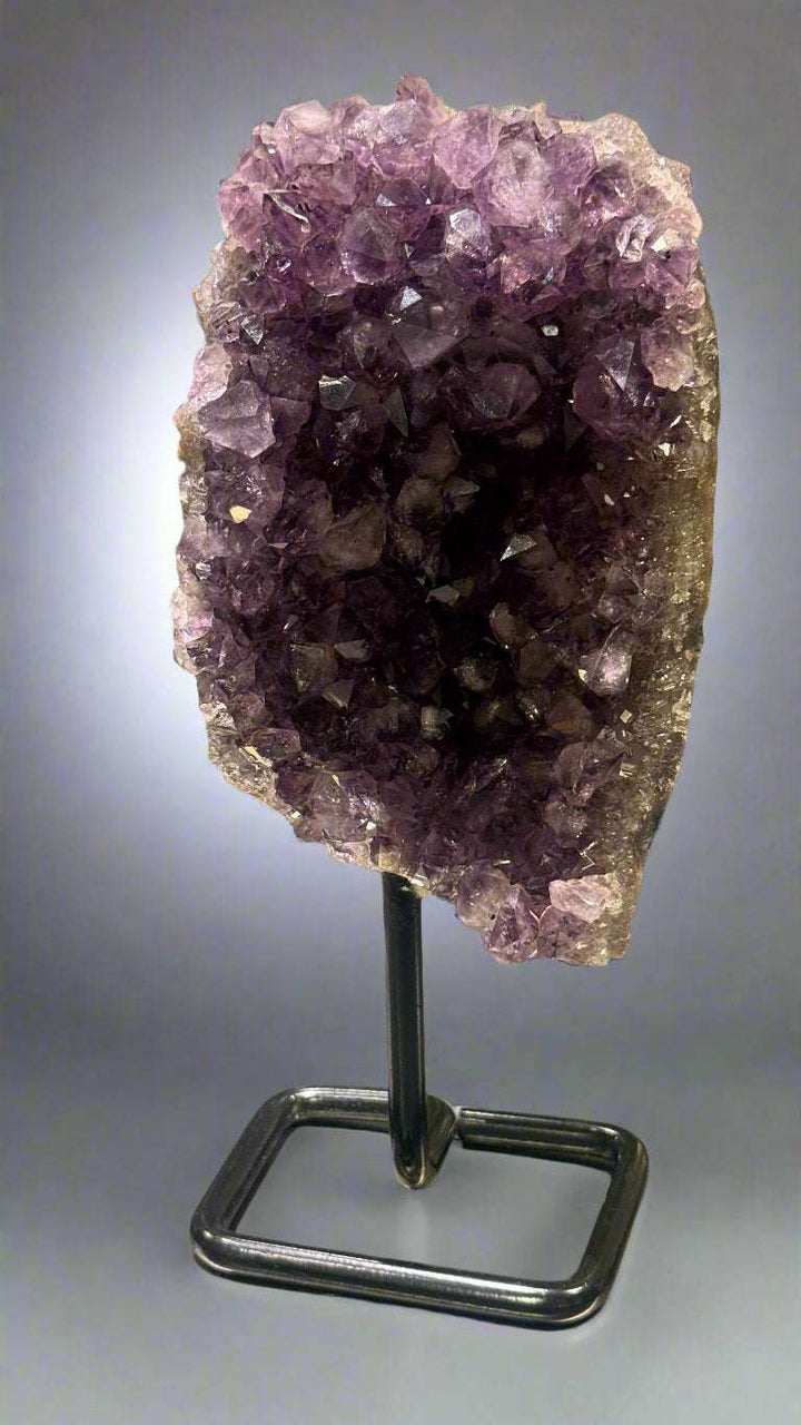 Amethyst crystal on a stand with a blurred background