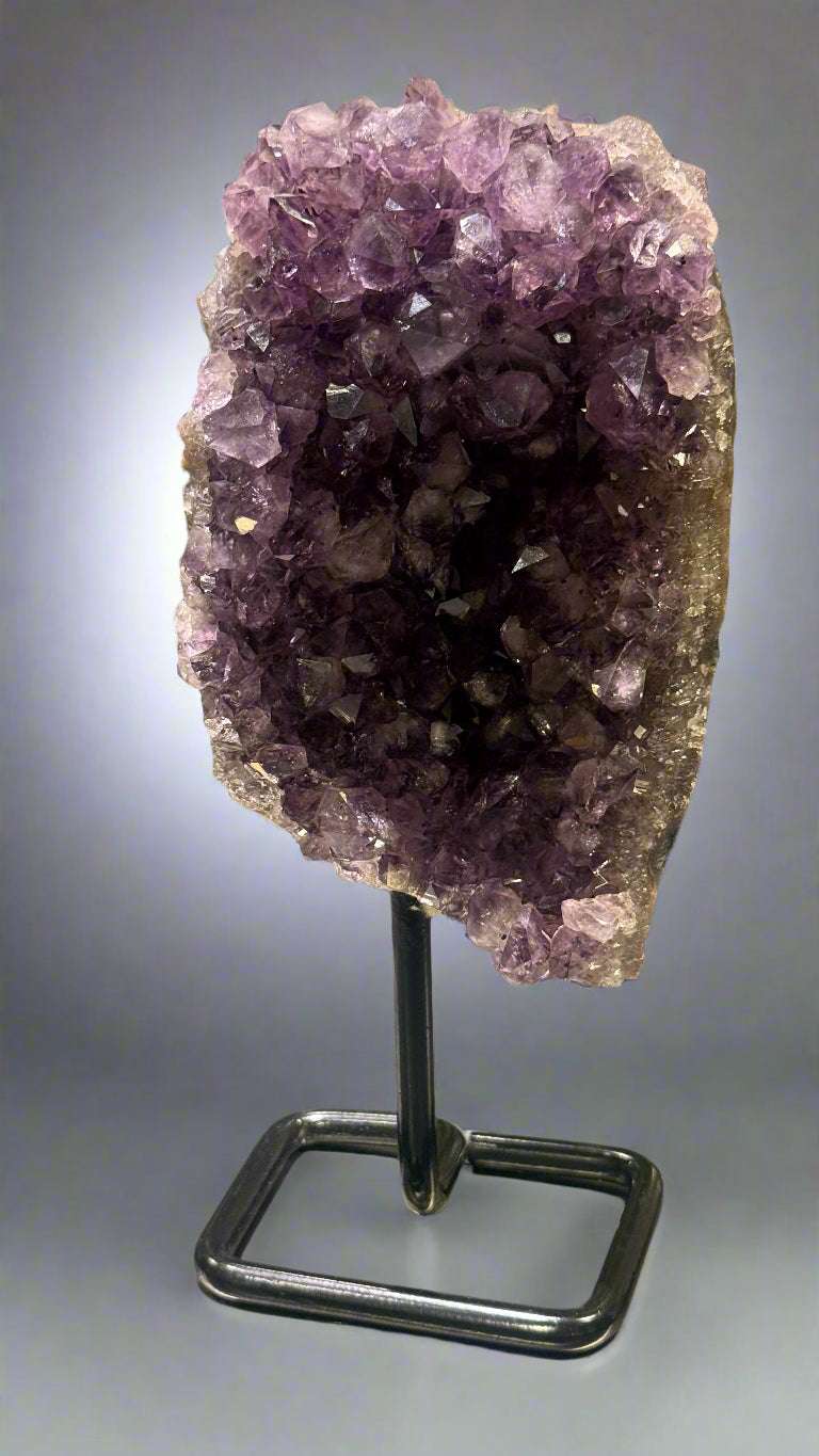 Amethyst crystal on a stand with a blurred background