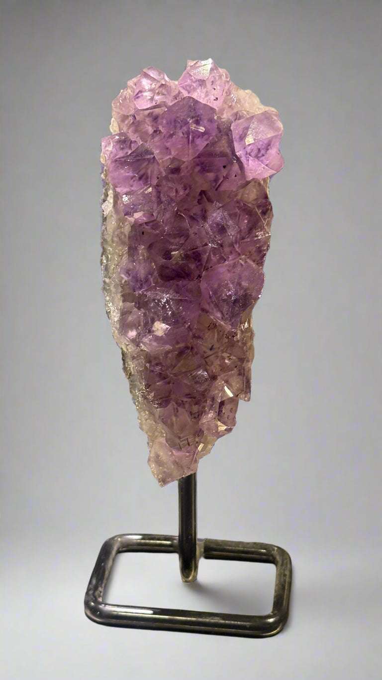 Amethyst crystal on a stand with a blurred background