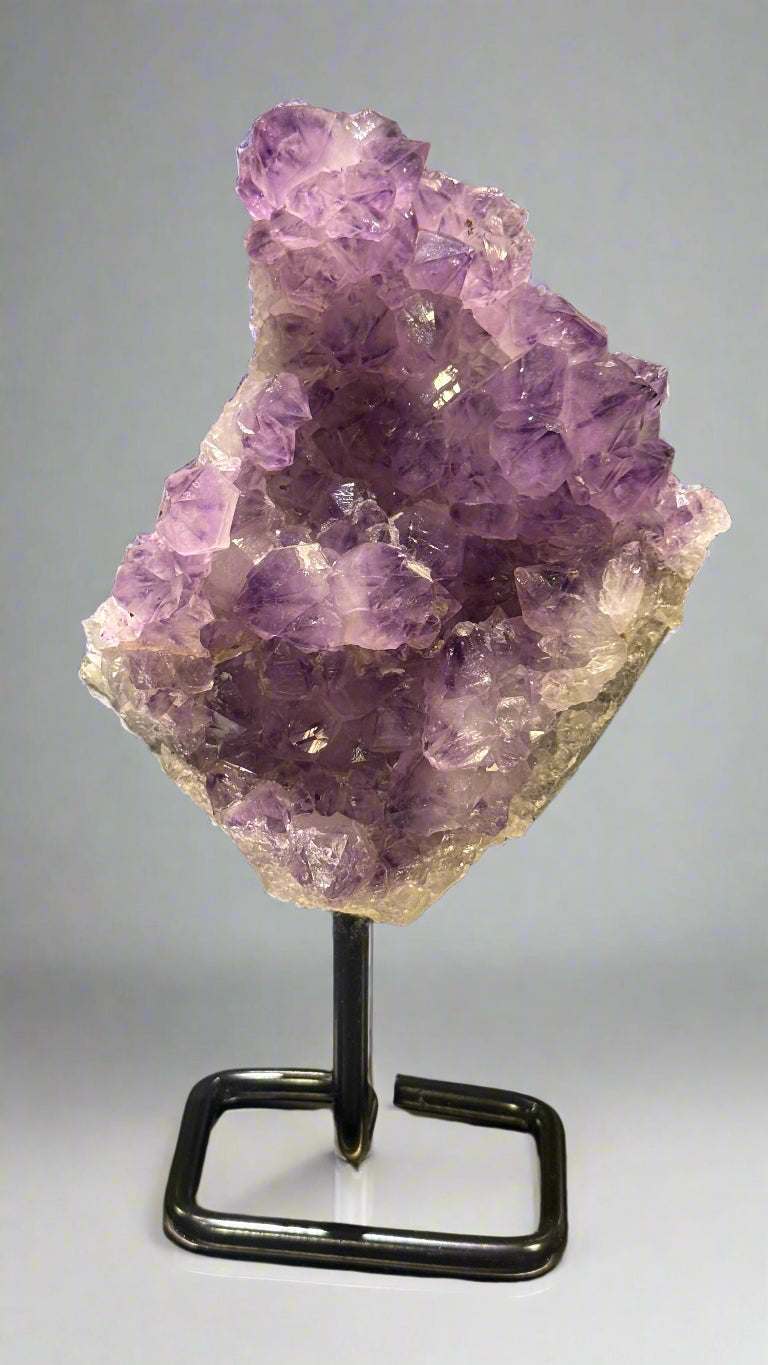 Amethyst crystal on a stand with a blurred background