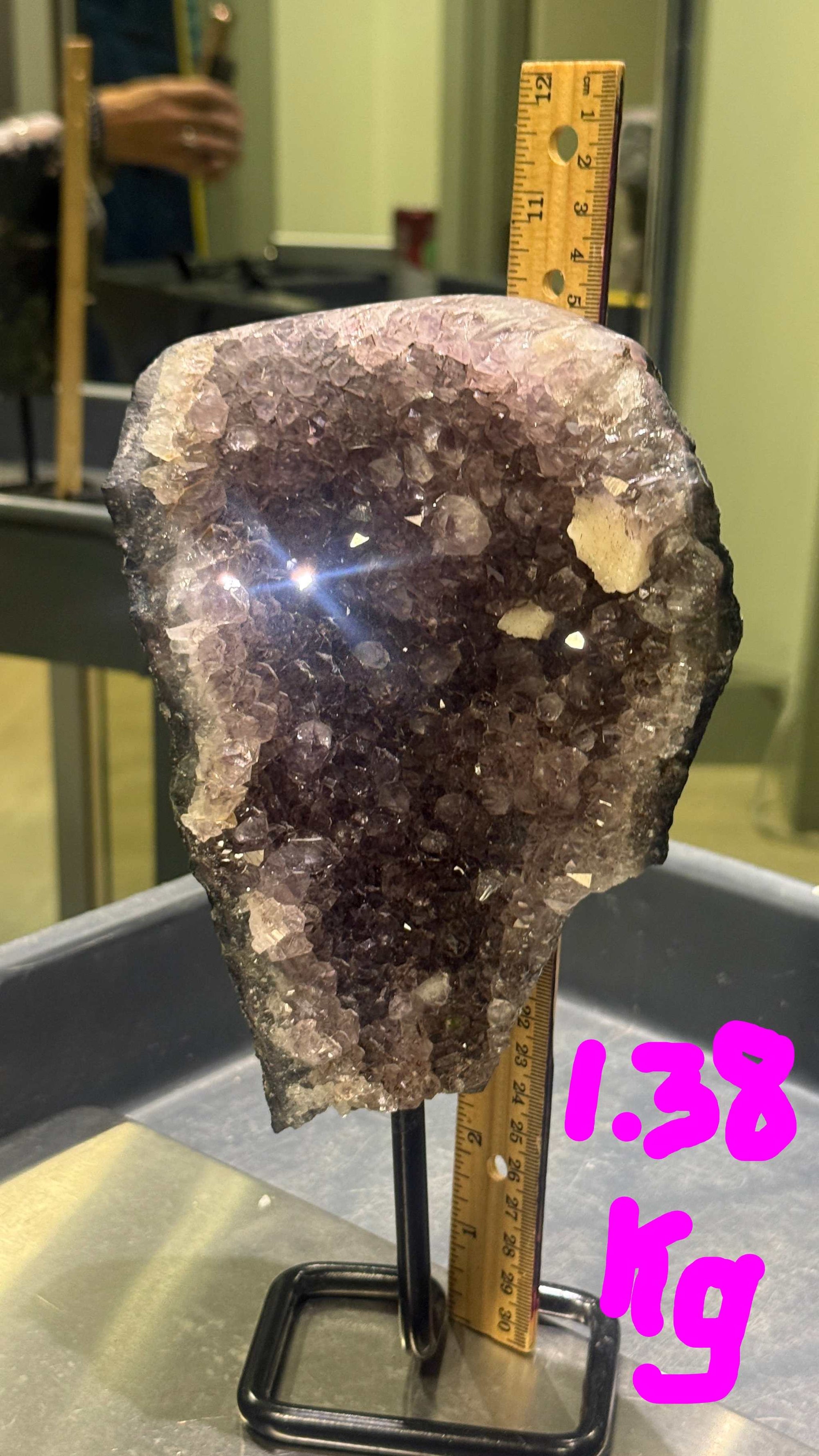 Crystal rock on a stand with a ruler for scale in an indoor setting