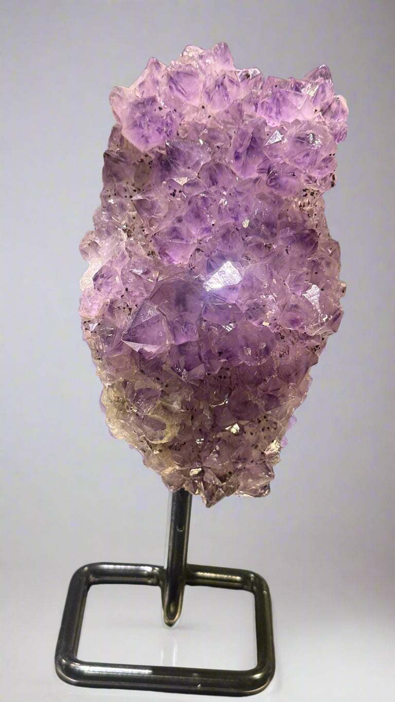Amethyst crystal on a stand with a blurred background