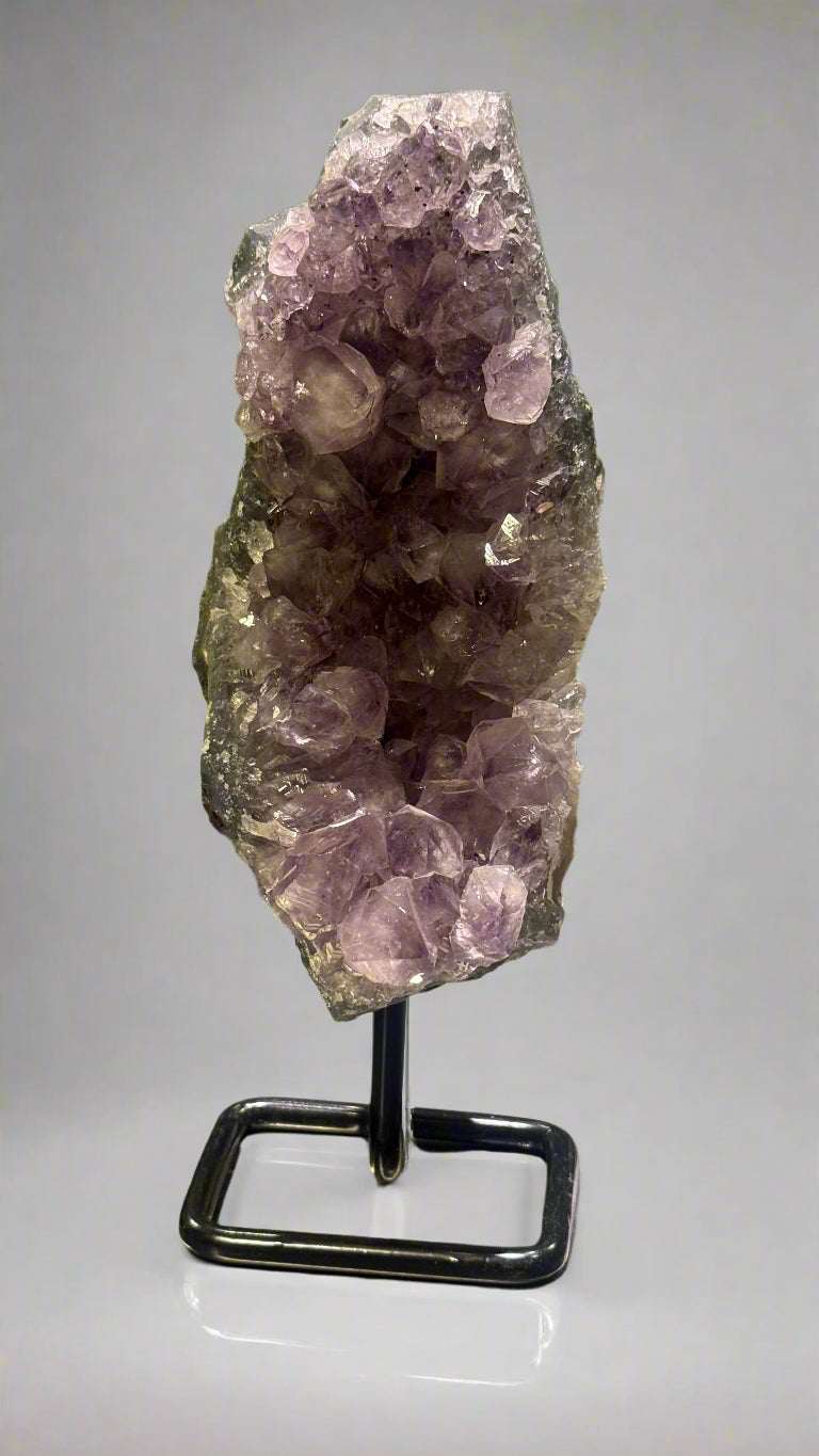 Amethyst crystal on a stand with a blurred background