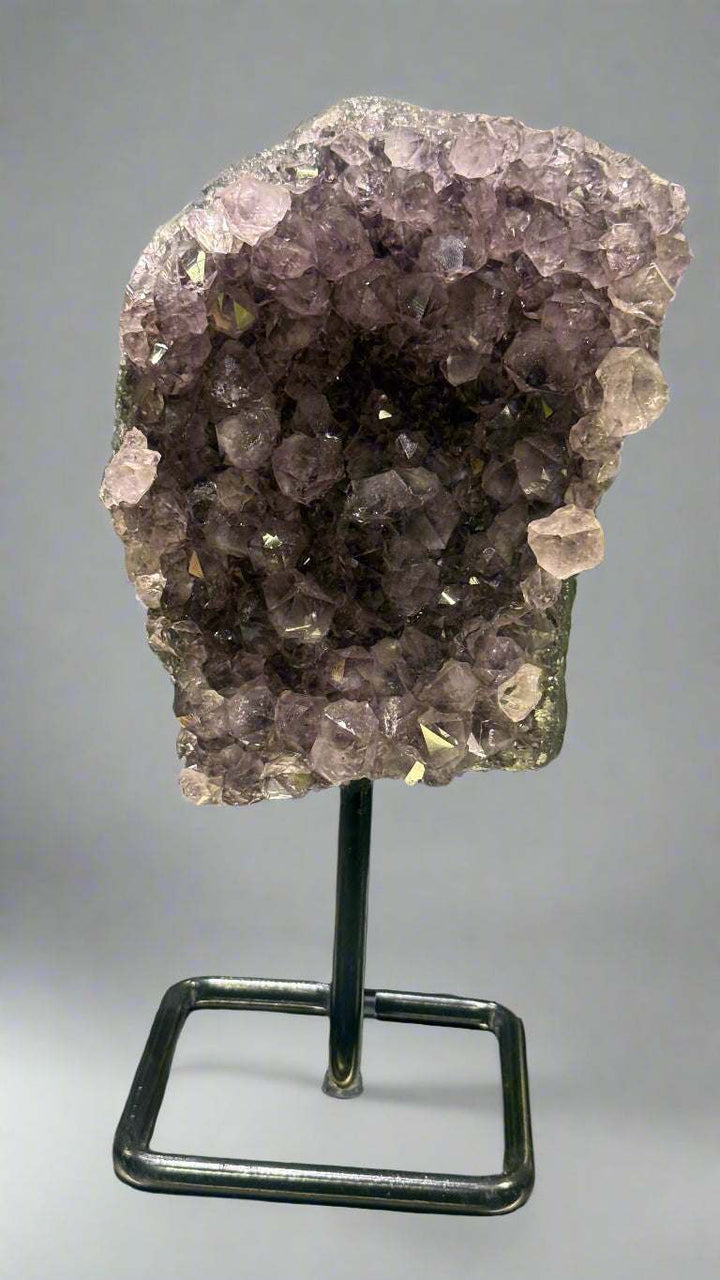 Amethyst crystal on a stand with a blurred background