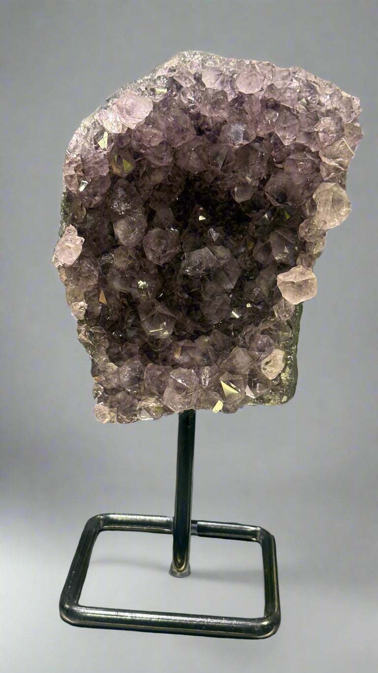 Amethyst crystal on a stand with a blurred background