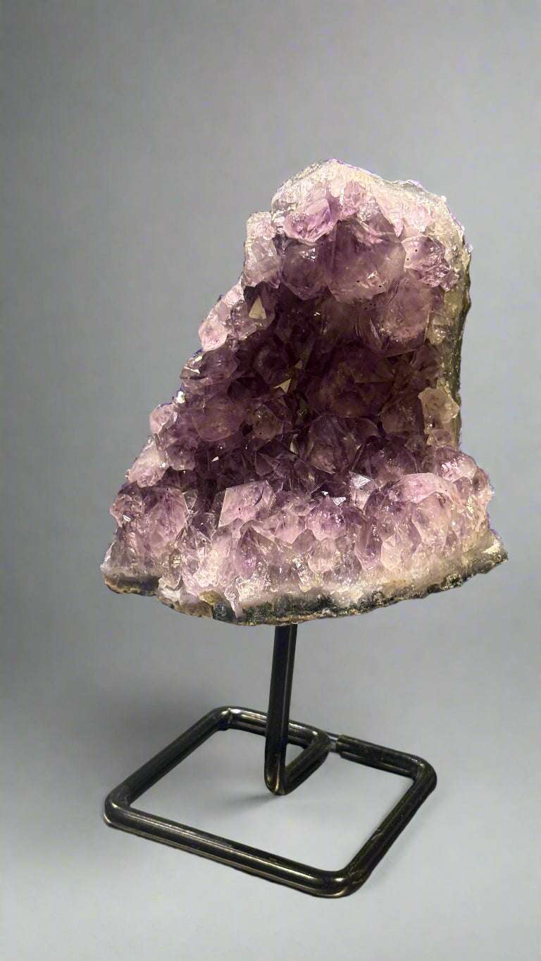 Amethyst crystal on a stand with a blurred background