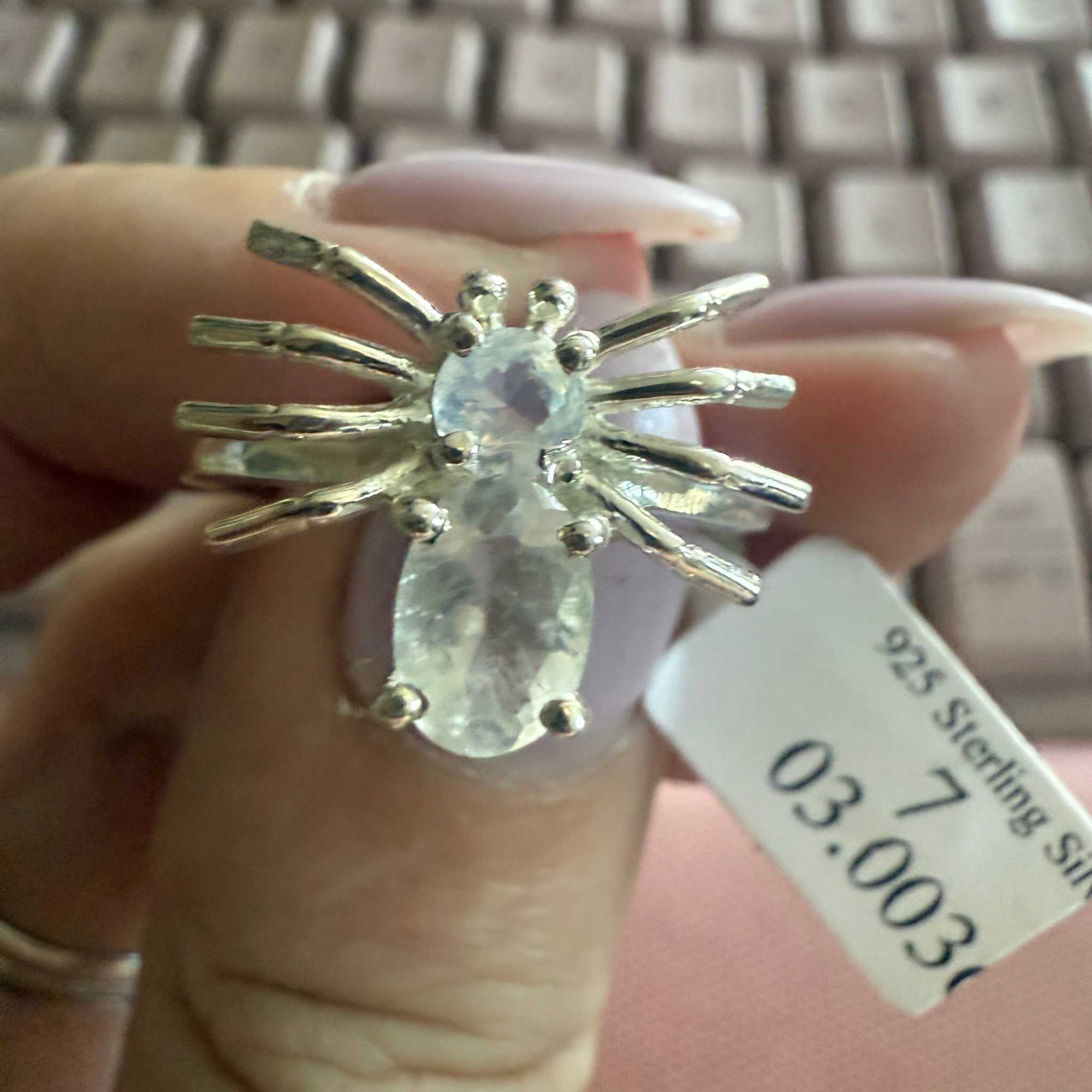 Spider ring with precious metal band and spider legs with gemstone spider body