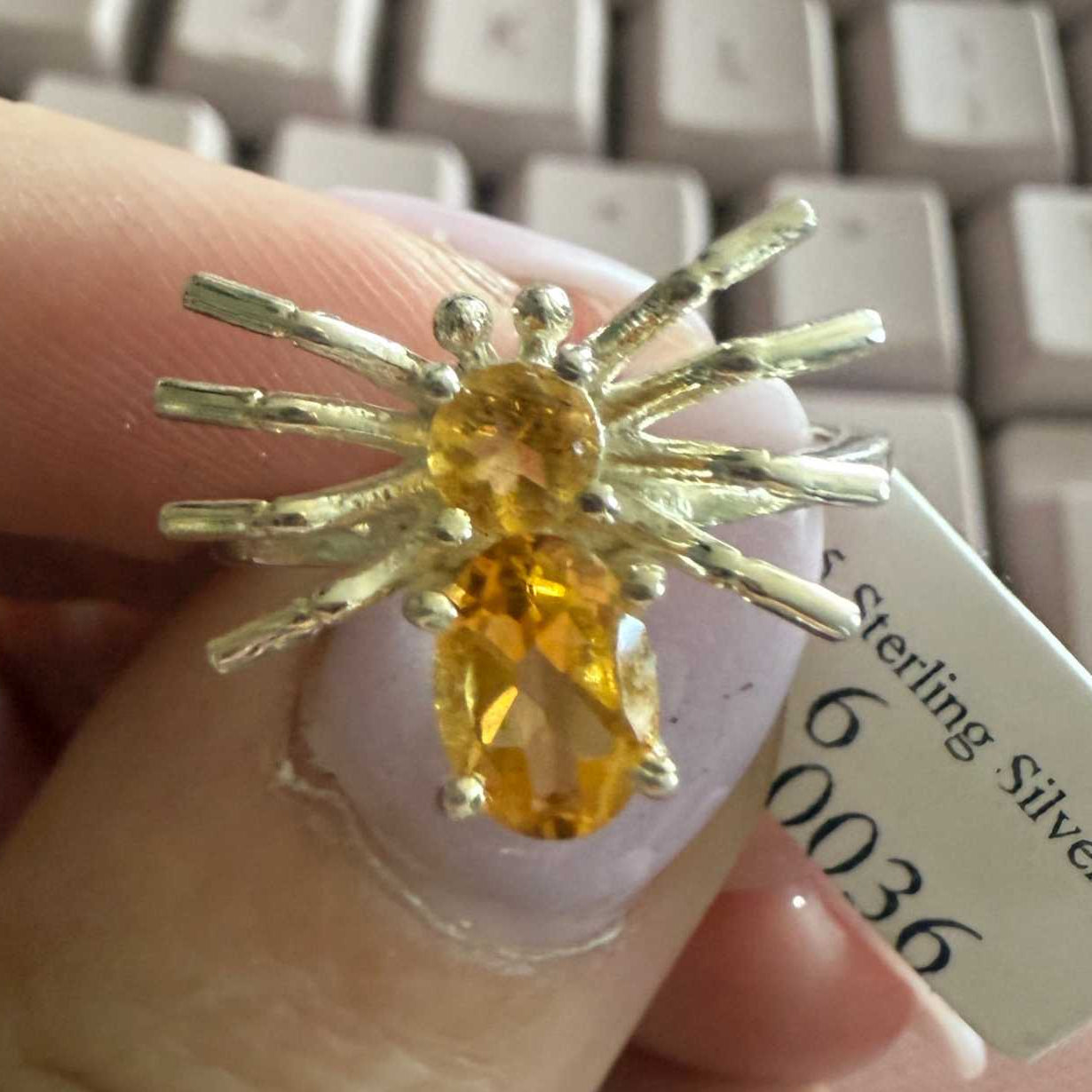 Spider ring with precious metal band and spider legs with gemstone spider body
