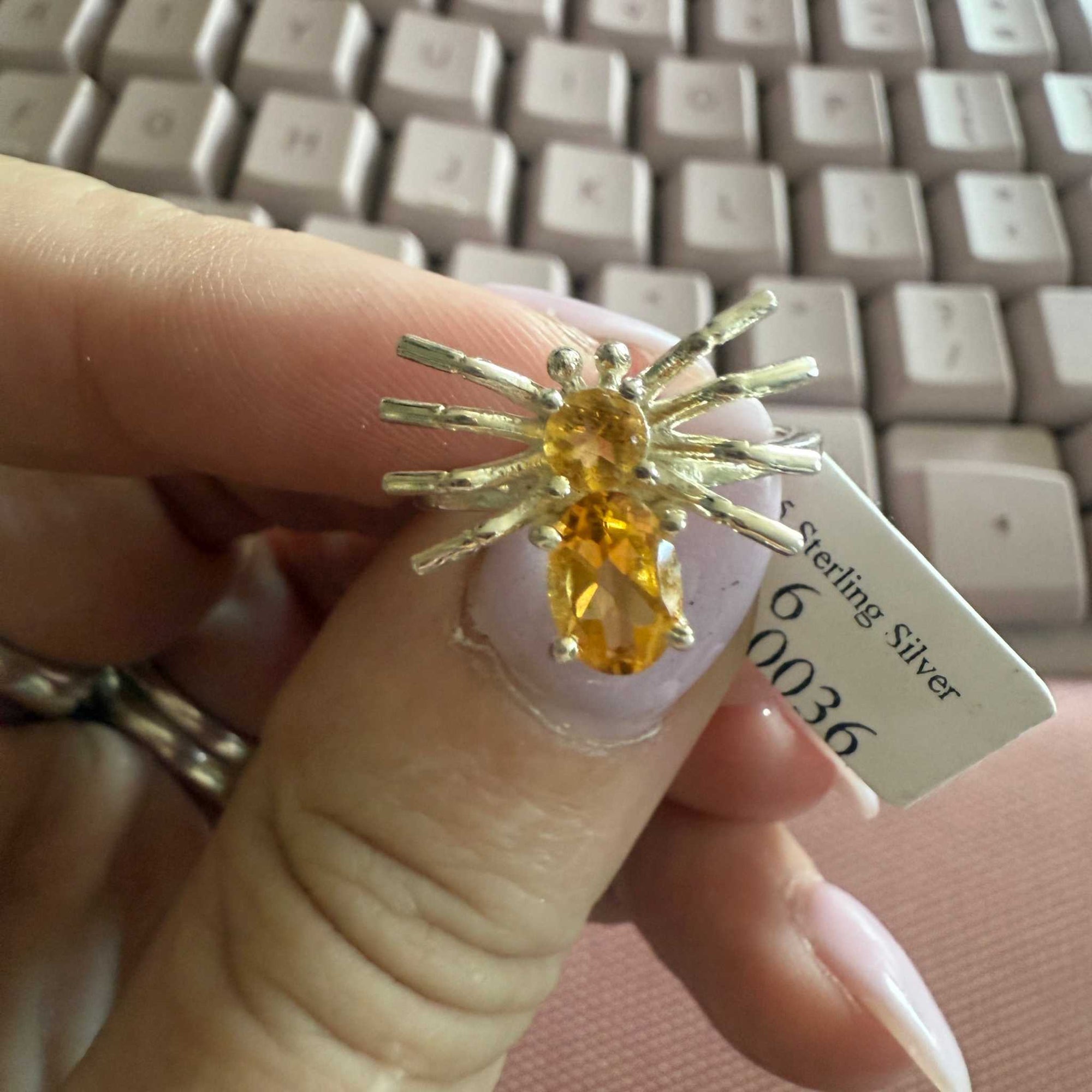 Spider ring with precious metal band and spider legs with gemstone spider body