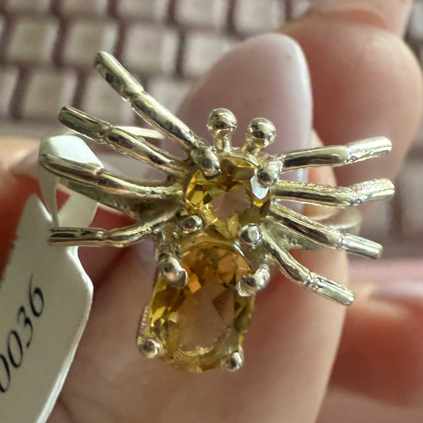 Spider ring with precious metal band and spider legs with gemstone spider body