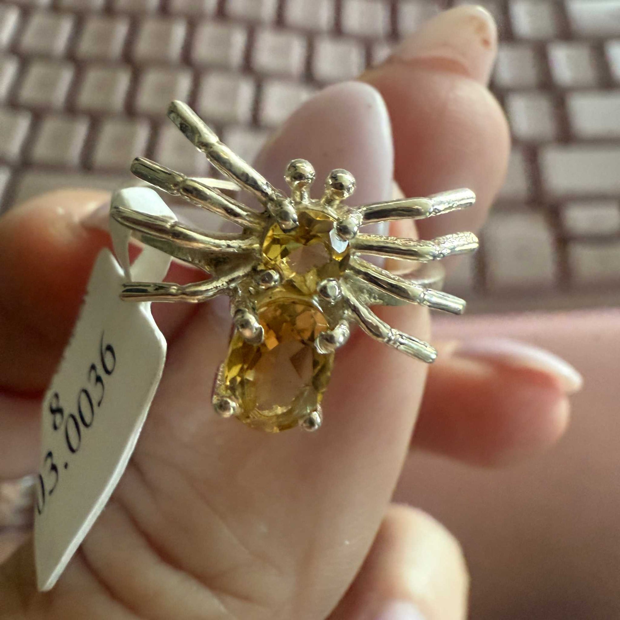 Spider ring with precious metal band and spider legs with gemstone spider body