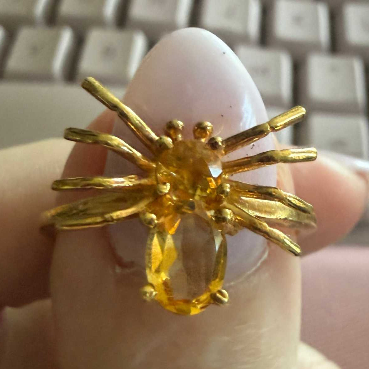 Spider ring with precious metal band and spider legs with gemstone spider body