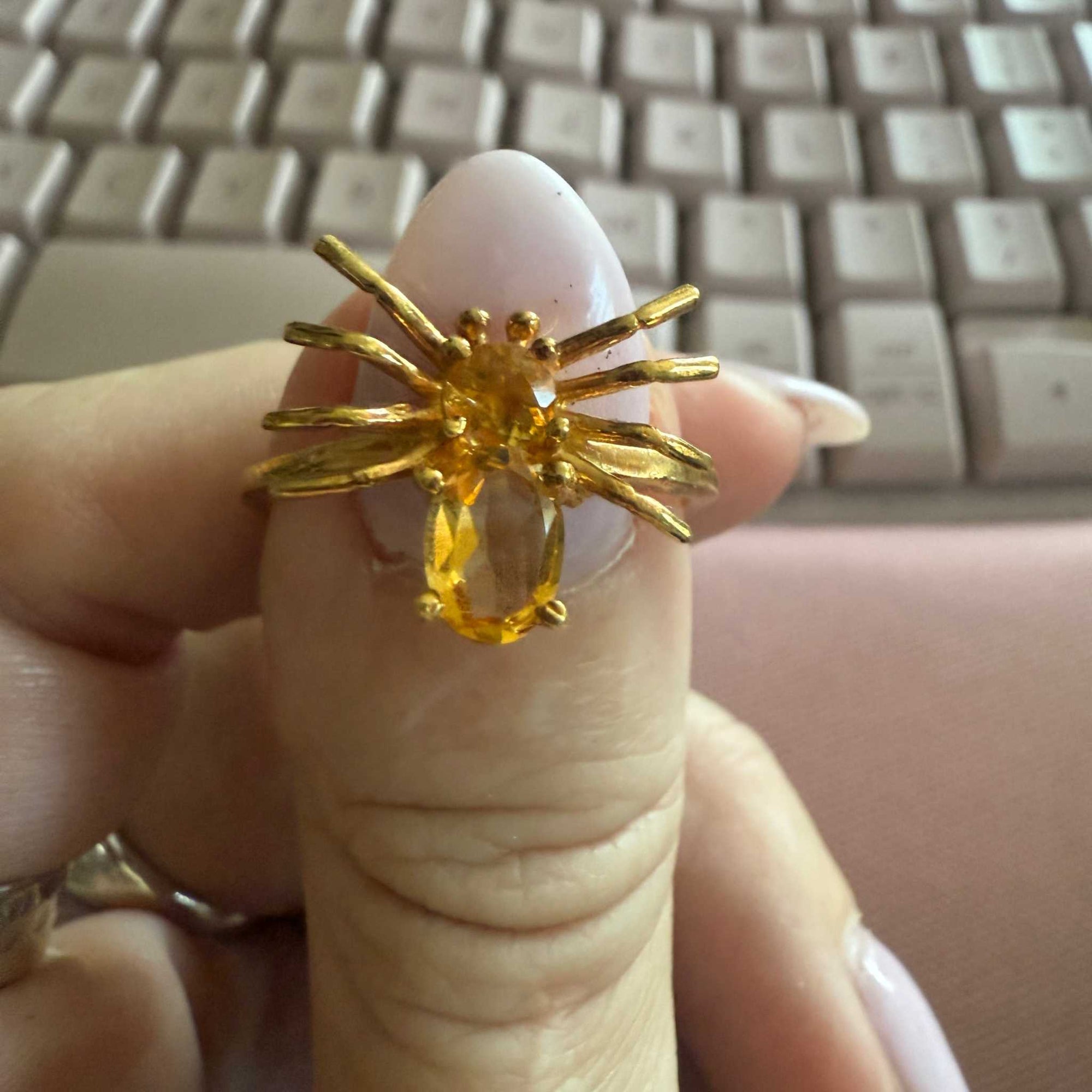 Spider ring with precious metal band and spider legs with gemstone spider body