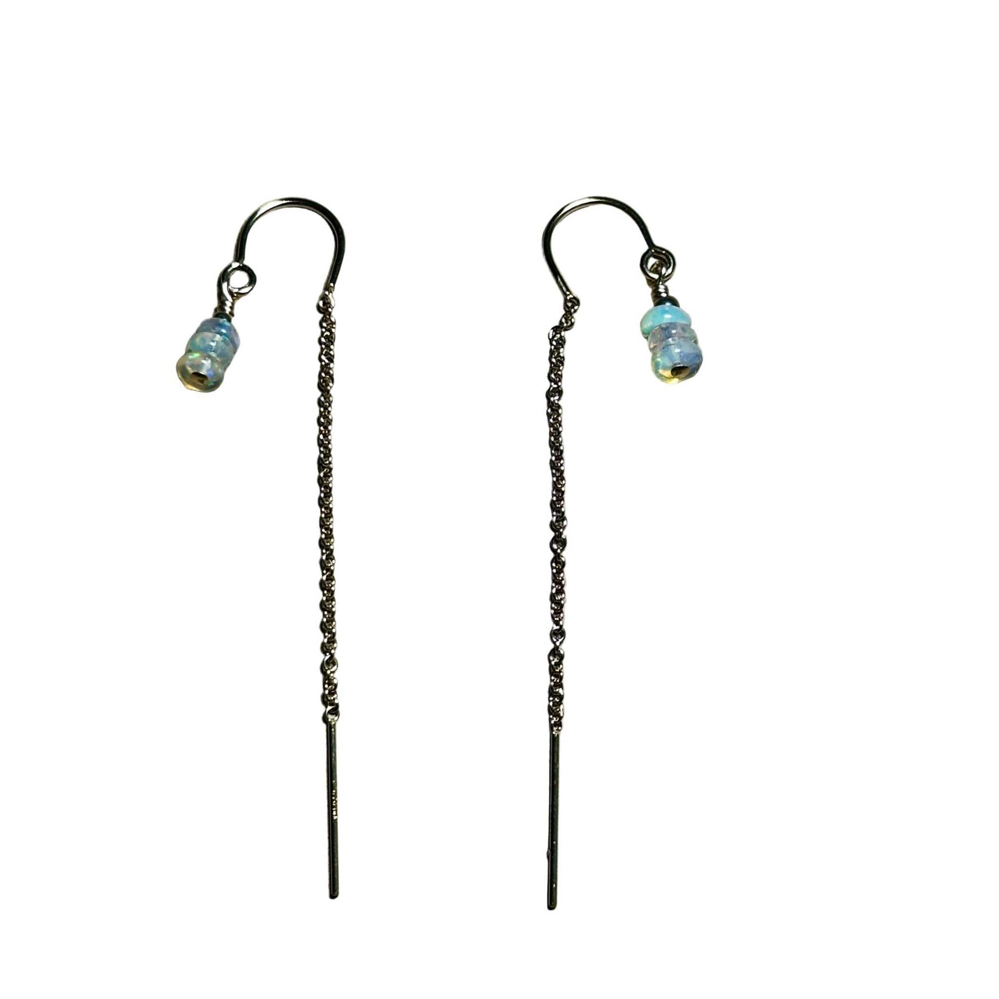 Pair of threader earrings with flashy opal beads on a surface