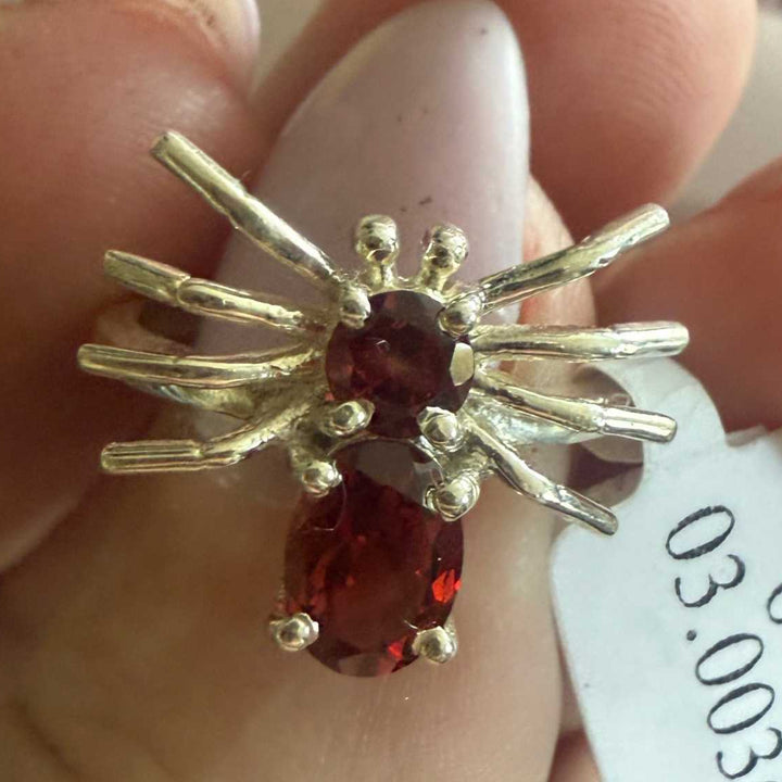 Spider ring with precious metal band and spider legs with gemstone spider body